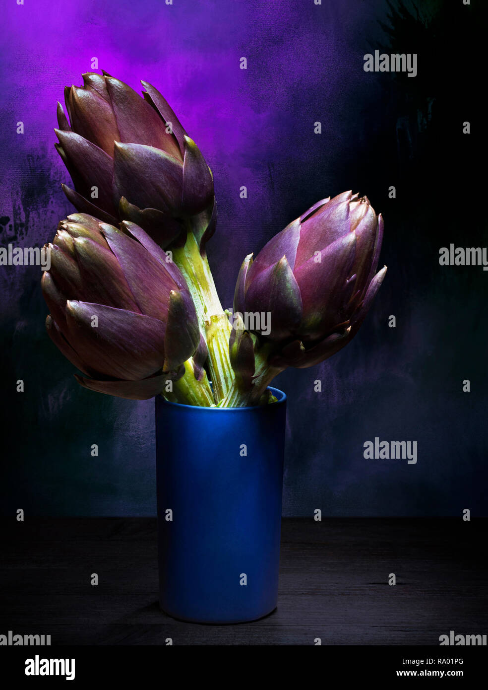 Artischocken in ein blaues Glas Vase. Immer noch leben, Licht Malerei. Stockfoto