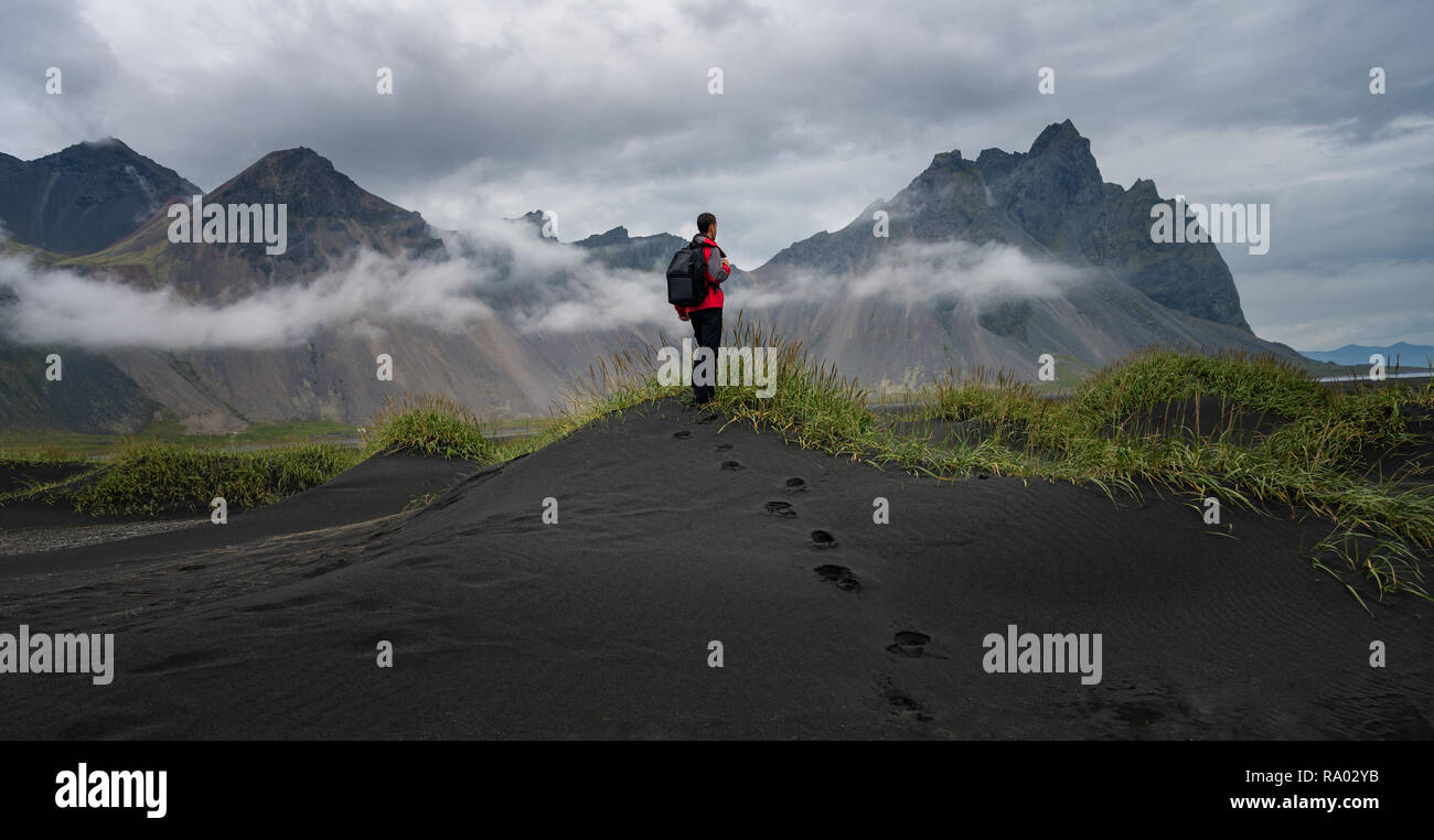 Reise nach Island, Mann stand auf schwarzem Sand Dünen in Stokksnes Stockfoto