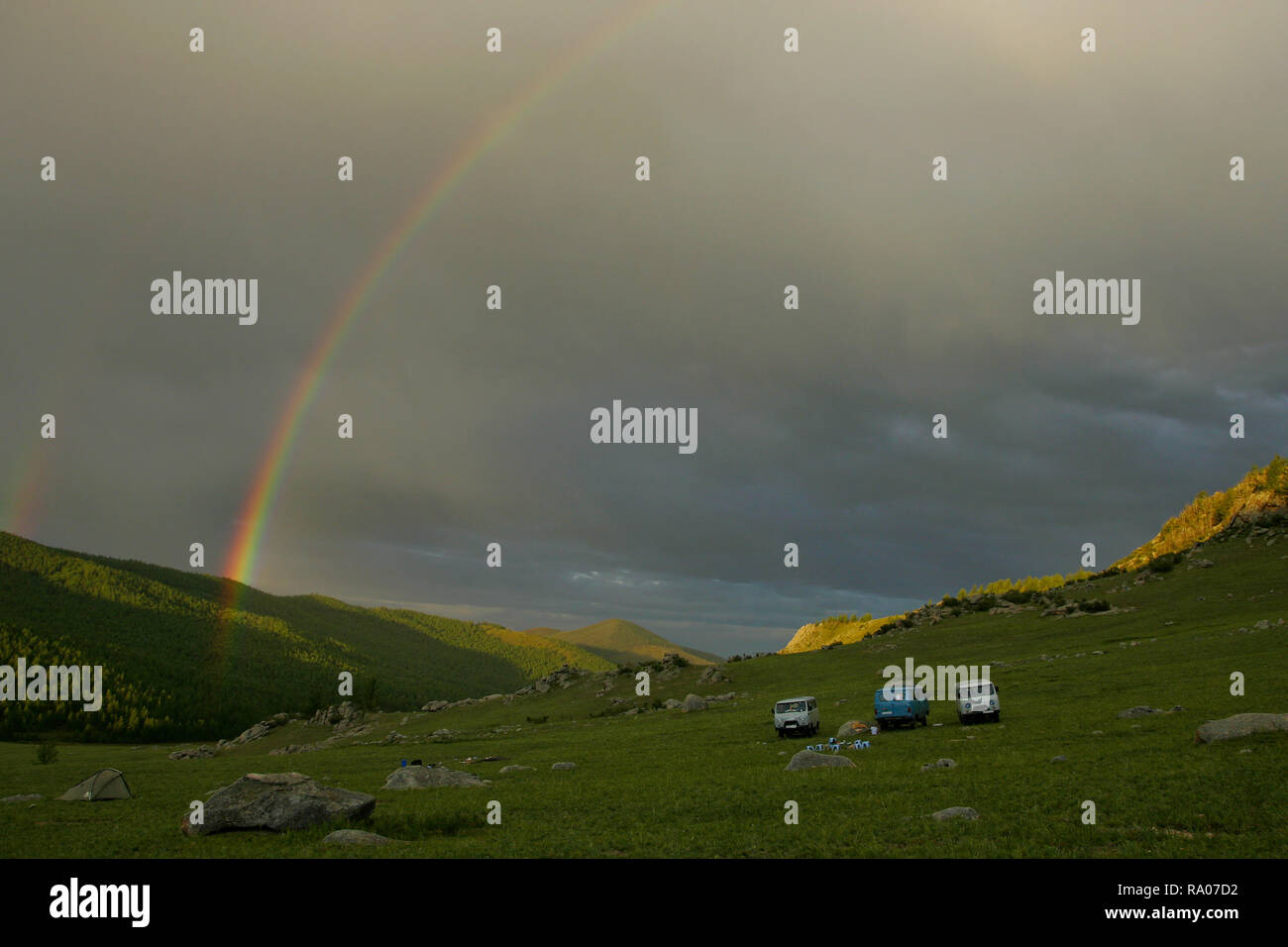 Intensive Regenbogen über Campingplatz mit Vans und Zelte im mongolischen Berge, gorkhi-terelj Nationalpark, Chentii-gebirges, Mongolei Stockfoto