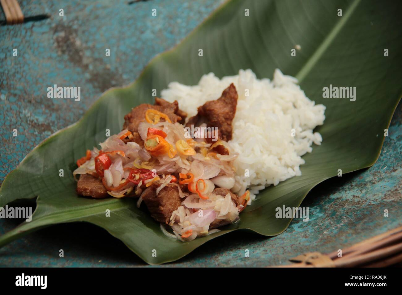 Babi Goreng Sambal Matah. Balinesisches Gericht von gebratenem Schweinefleisch Würfeln mit frischen salsa von Schalotten und Zitronengras. Stockfoto