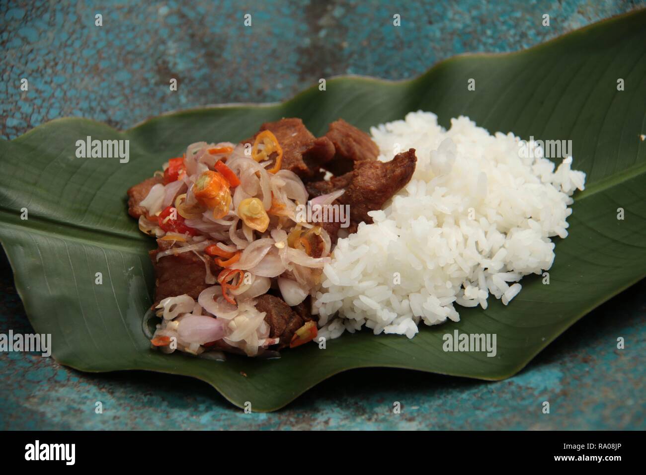 Babi Goreng Sambal Matah. Balinesisches Gericht von gebratenem Schweinefleisch Würfeln mit frischen salsa von Schalotten und Zitronengras. Stockfoto