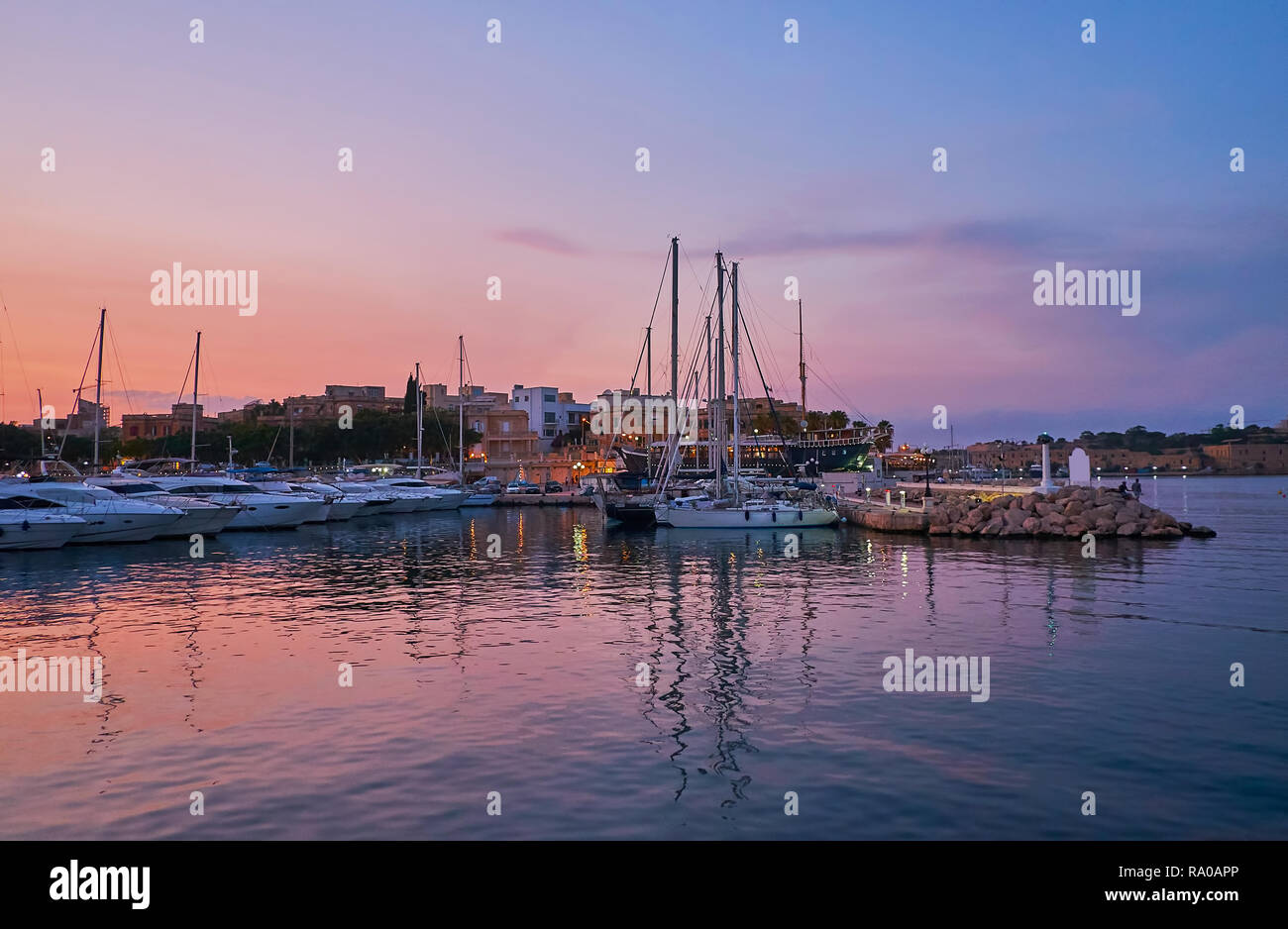 Die Werften mit angelegten Yachten in Abend Msida Yacht Marina, die violette Twilight Sky auf dem Wasser Oberfläche reflektiert, Malta. Stockfoto