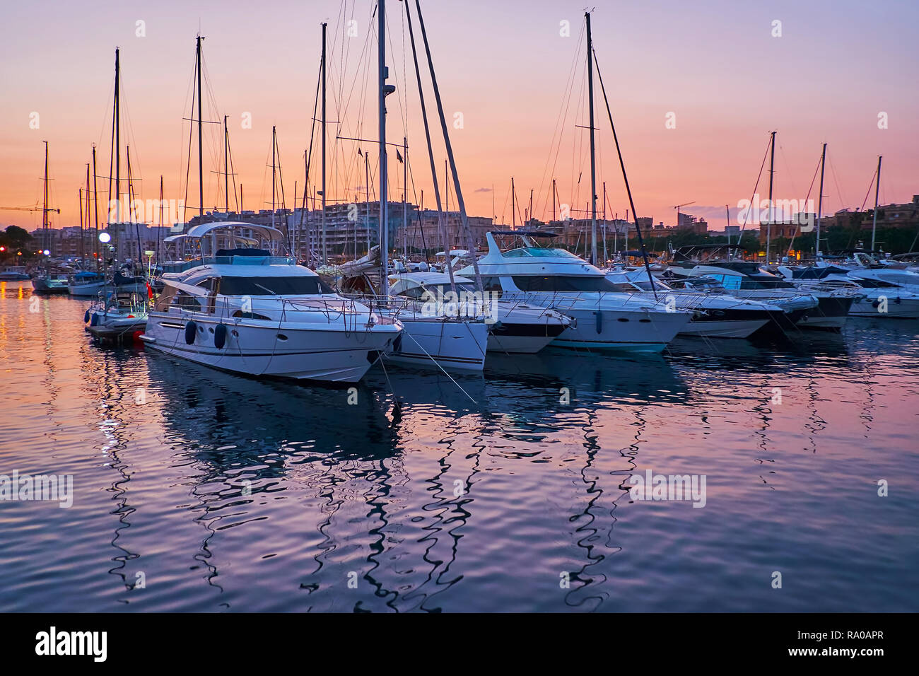 Den Abend in Msida Yacht Marina genießen, moderne Schiffe spiegeln sich in dunklen Gewässern, Malta. Stockfoto
