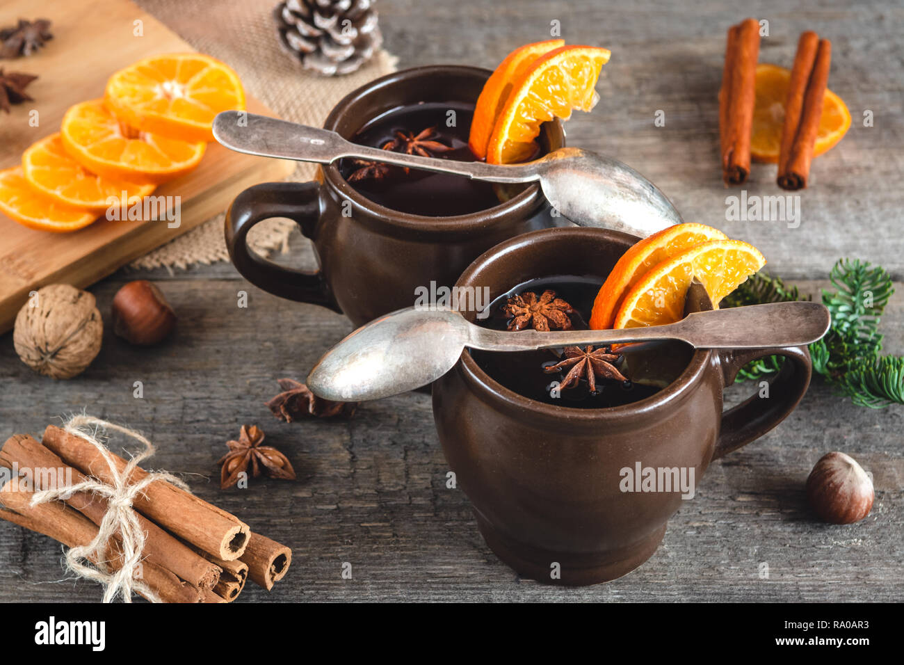 Heißer Glühwein mit Orange, Zimt, Honig und Anis auf Holz- Hintergrund. Stockfoto