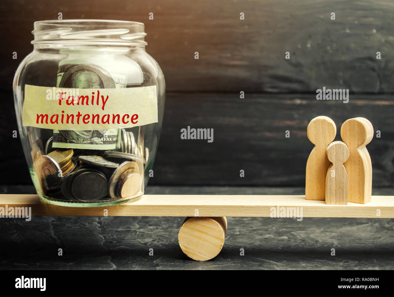 Glas Glas mit Geld und die Worte "Familienmitglieder" und die Familie auf der Waage. Das Konzept der medizinischen Versicherung des Lebens, der Familie, der Gesundheit. Heilen Stockfoto