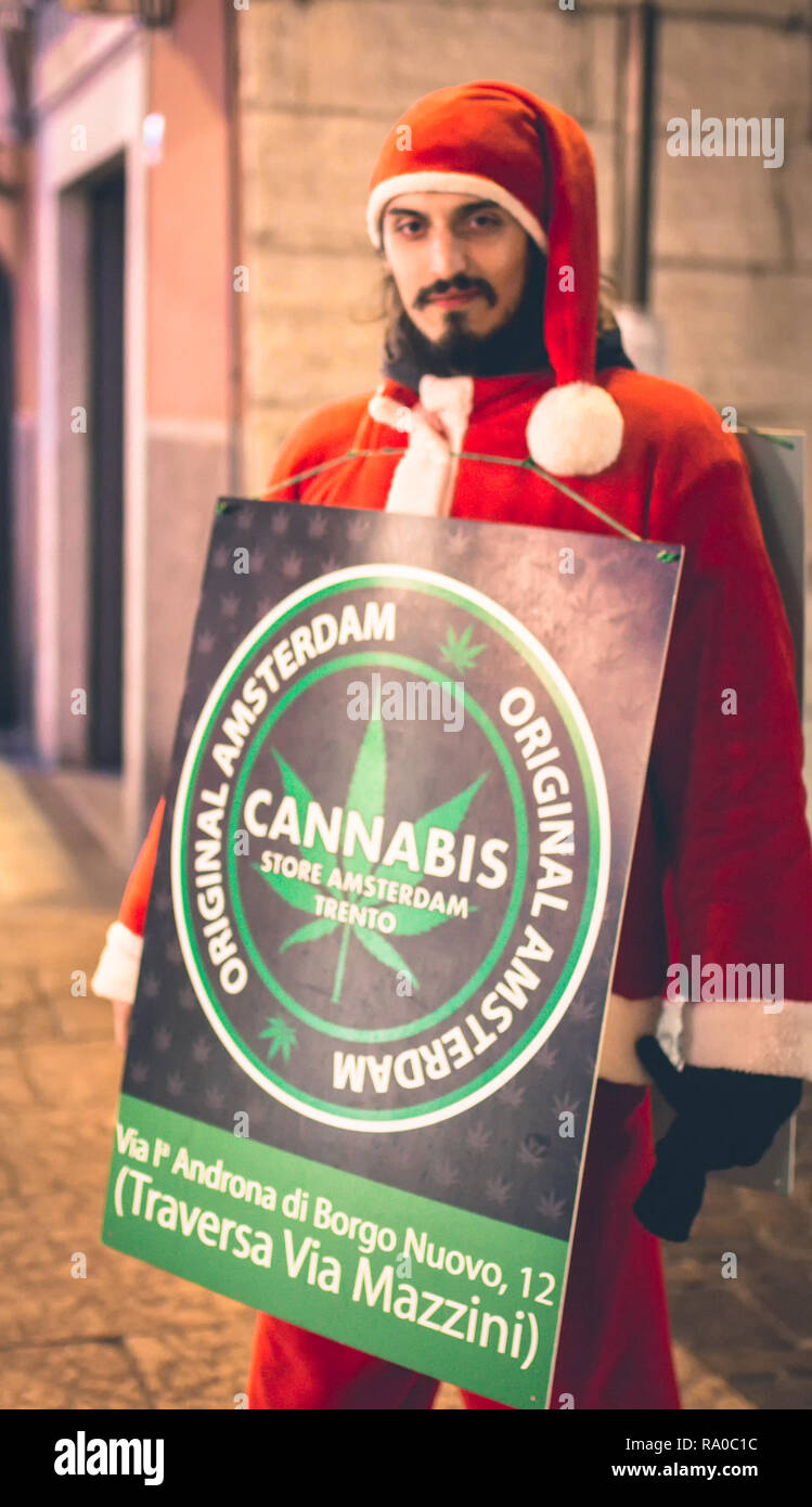 Mann verkleidet als Weihnachtsmann die Cannabis shop während des Weihnachtsmarktes in Trient wirbt, Trentino Alto Adige, Italien. Stockfoto