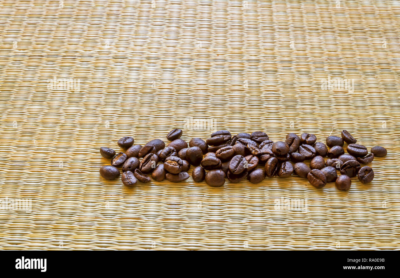 Kaffee Bohnen auf einem Bambus Hintergrund mit Platz für Kopieren oder die Platzierung von Los Fotos. Stockfoto
