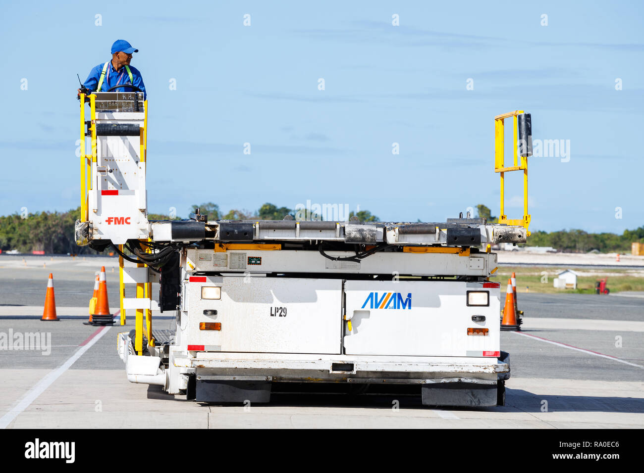 Punta Cana, Dominikanische Republik - 24. Dezember 2018: Ein Flughafen Mitarbeiter am Internationalen Flughafen Punta Cana Betriebsmittel Ladung zu laden Ai Stockfoto