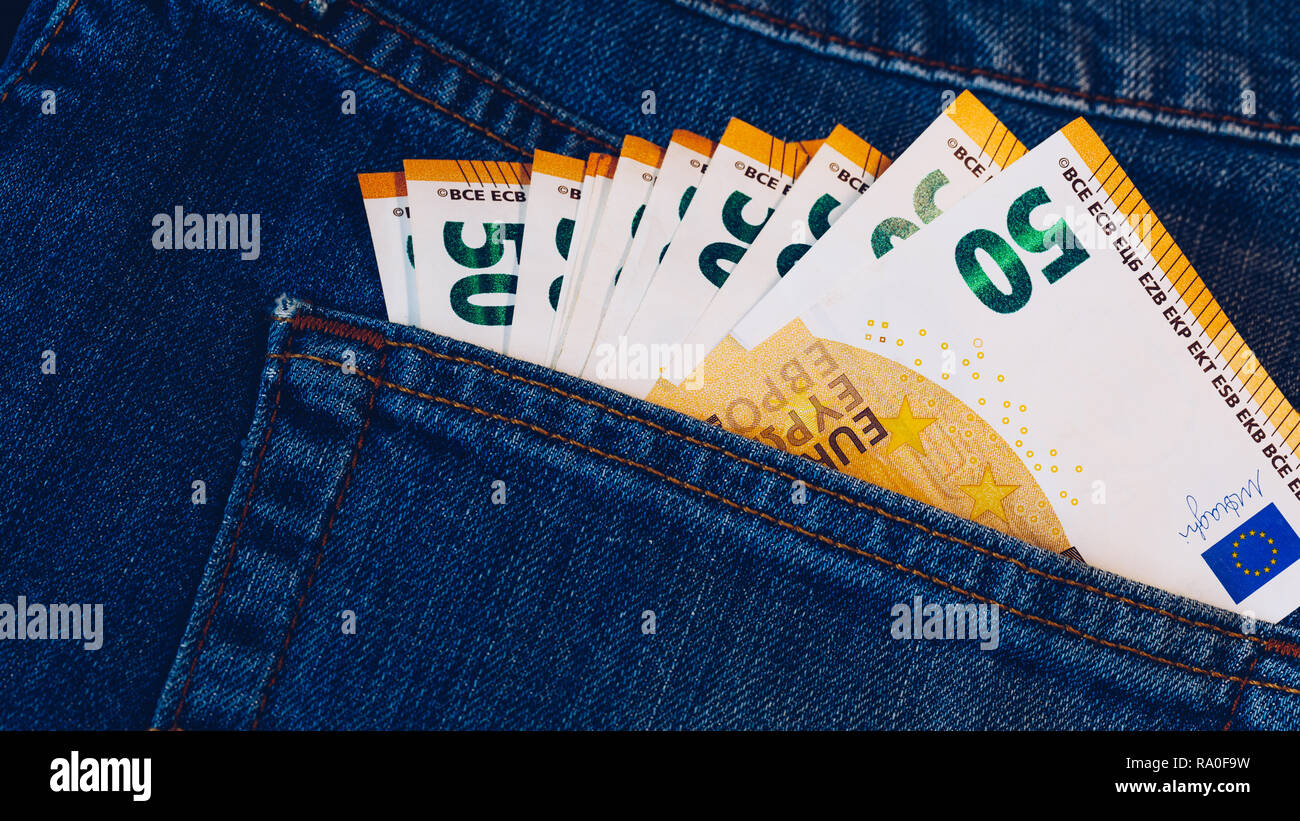 Euro Rechnungen in Jeans pocket Hintergrund. Euro-banknoten in Jeans Gesäßtasche. Konzept der reiche Leute, Speichern oder Geld auszugeben. Euro Rechnungen herausfallen. Stockfoto