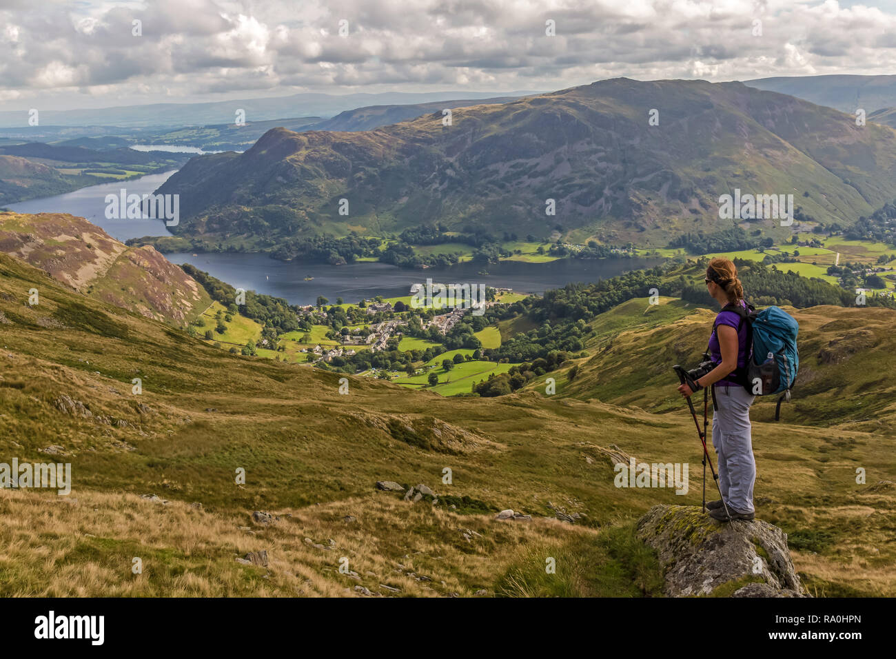 Weibliche Wanderer auf der Suche nach unten in Richtung Ullswater und Glenridding, im Lake District National Park in Cumbria, England. Stockfoto
