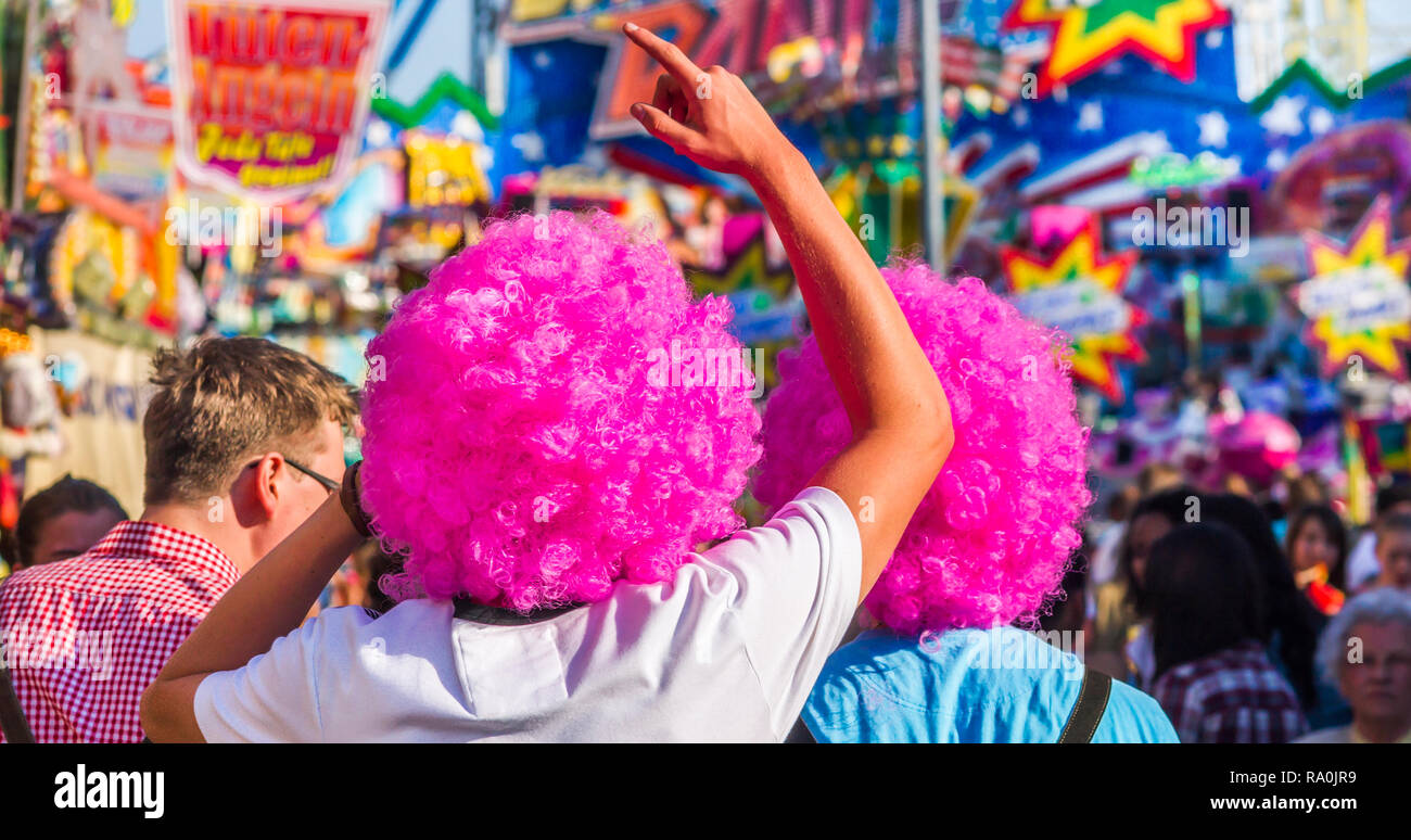 Feiern junge Männer mit pink afro Perücken bei Cannstatt/Stuttgart Kirmes Stockfoto