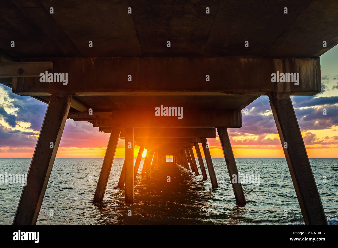 Spektakuläre Sonnenuntergänge über Glenelg jetty Masten gesehen, South Australia Stockfoto