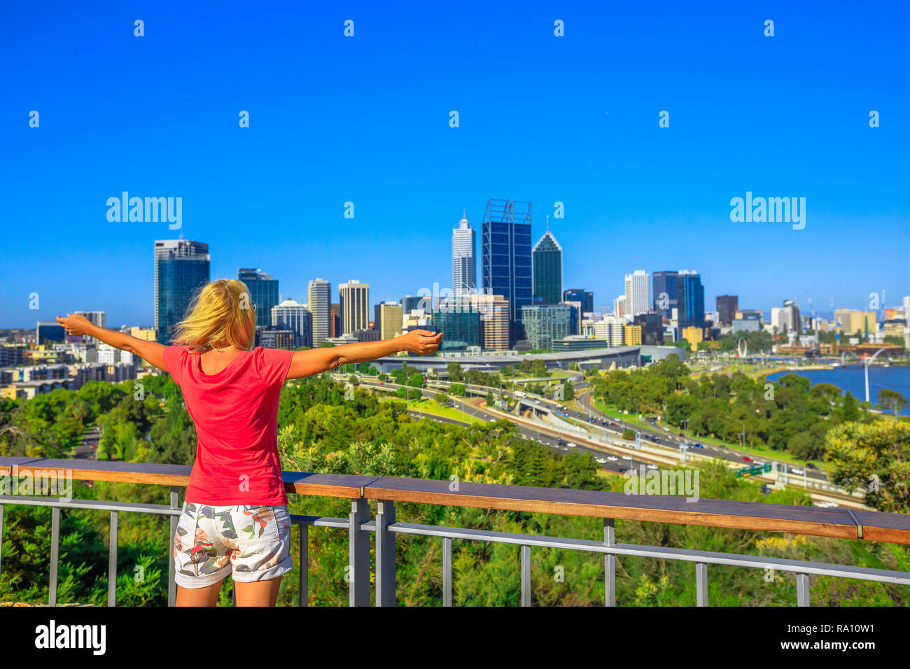 Sorglos Frau mit Blick auf Perth Wasser, ein Abschnitt des Swan River, und Central Business District von Perth vom Kings Park, dem beliebtesten Besucher Ziel in Western Australia. Blauer Himmel, Platz kopieren Stockfoto