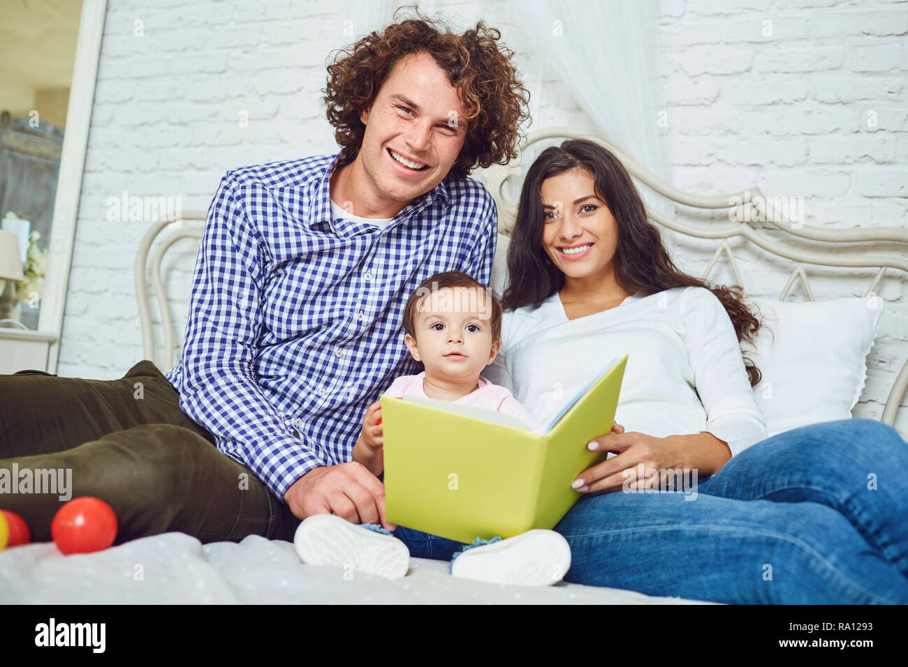 Mutter, Vater und Kind liest ein Buch zu Hause Stockfoto