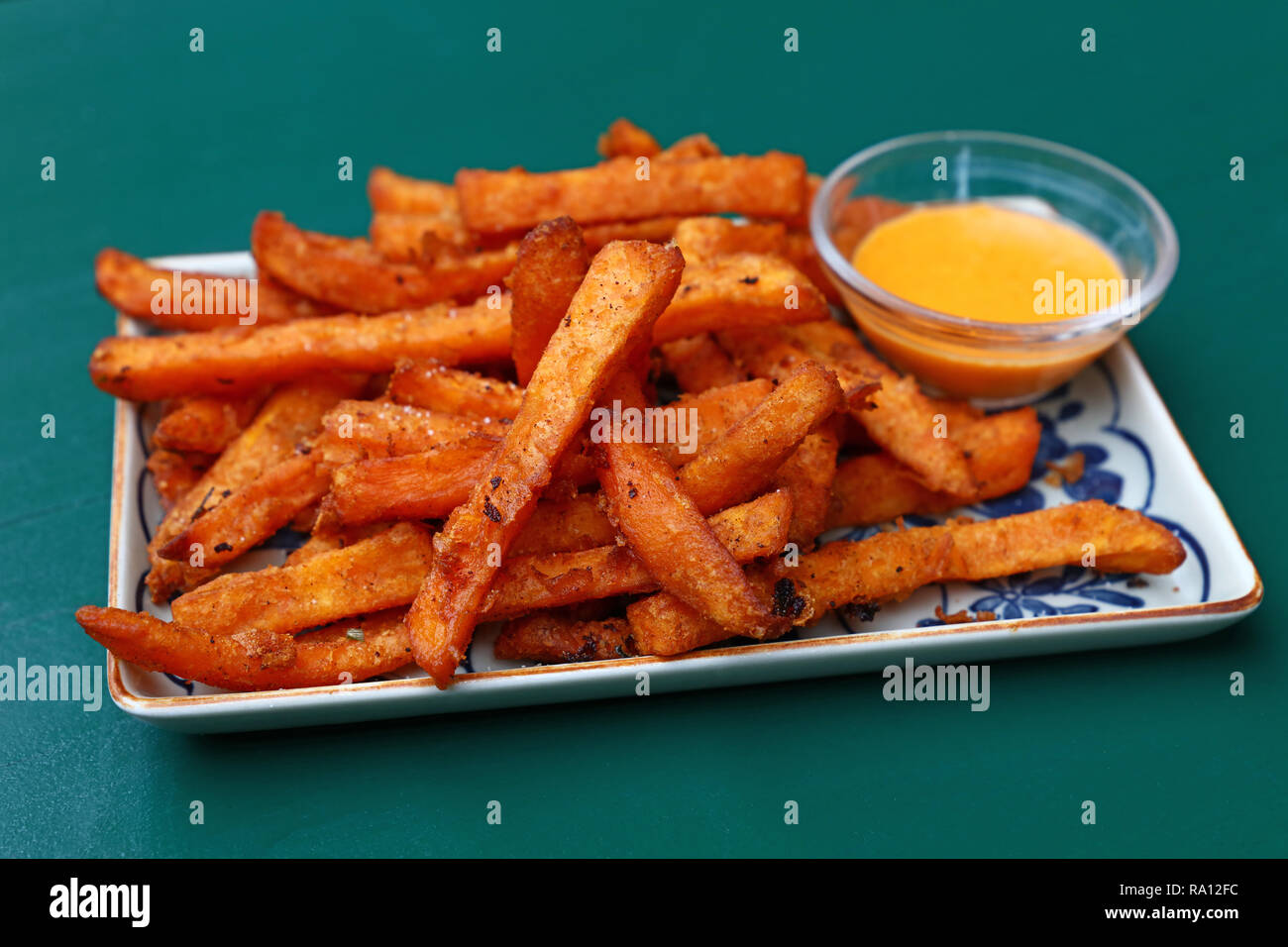 Portion frittierter Kartoffel Chips oder Pommes mit Soße auf die Platte über der Tabelle, hohe Betrachtungswinkel Stockfoto