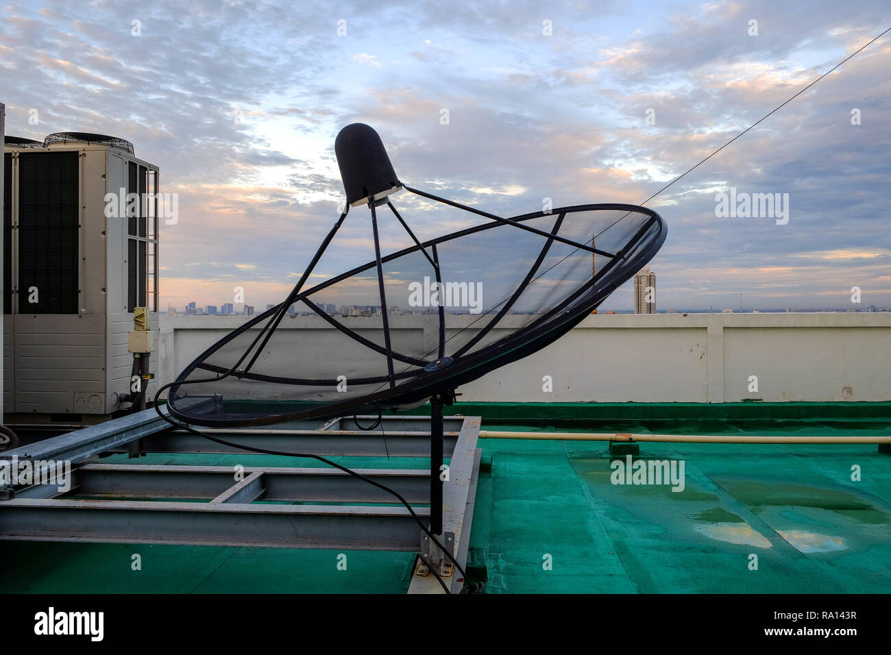 Satellitenschüssel Empfänger und Klimaanlage stand auf dem Dach des Gebäudes. Stockfoto