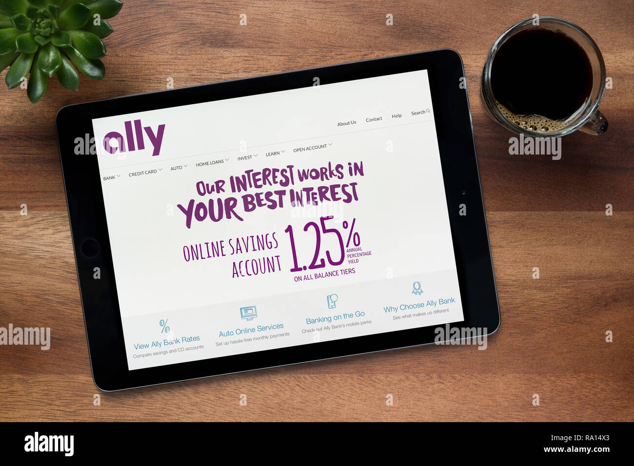 Die Website der Ally Bank ist auf einem iPad Tablet gesehen, auf einer hölzernen Tisch zusammen mit einem Espresso und einem Haus Anlage (nur redaktionelle Nutzung). Stockfoto