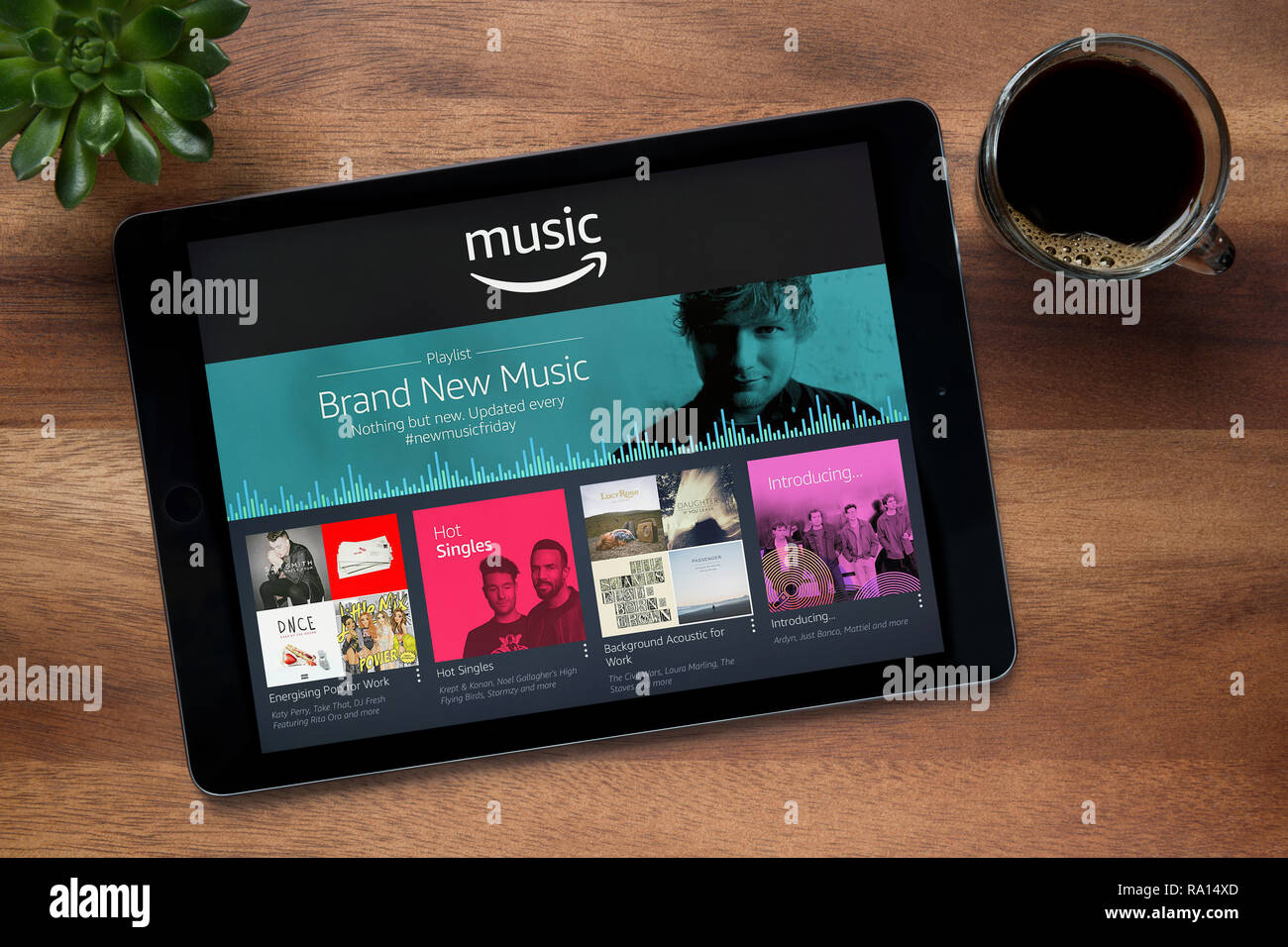 Die Amazon Musik App auf dem iPad Tablet gesehen, auf einer hölzernen Tisch zusammen mit einem Espresso und einem Haus Anlage (nur redaktionelle Nutzung). Stockfoto