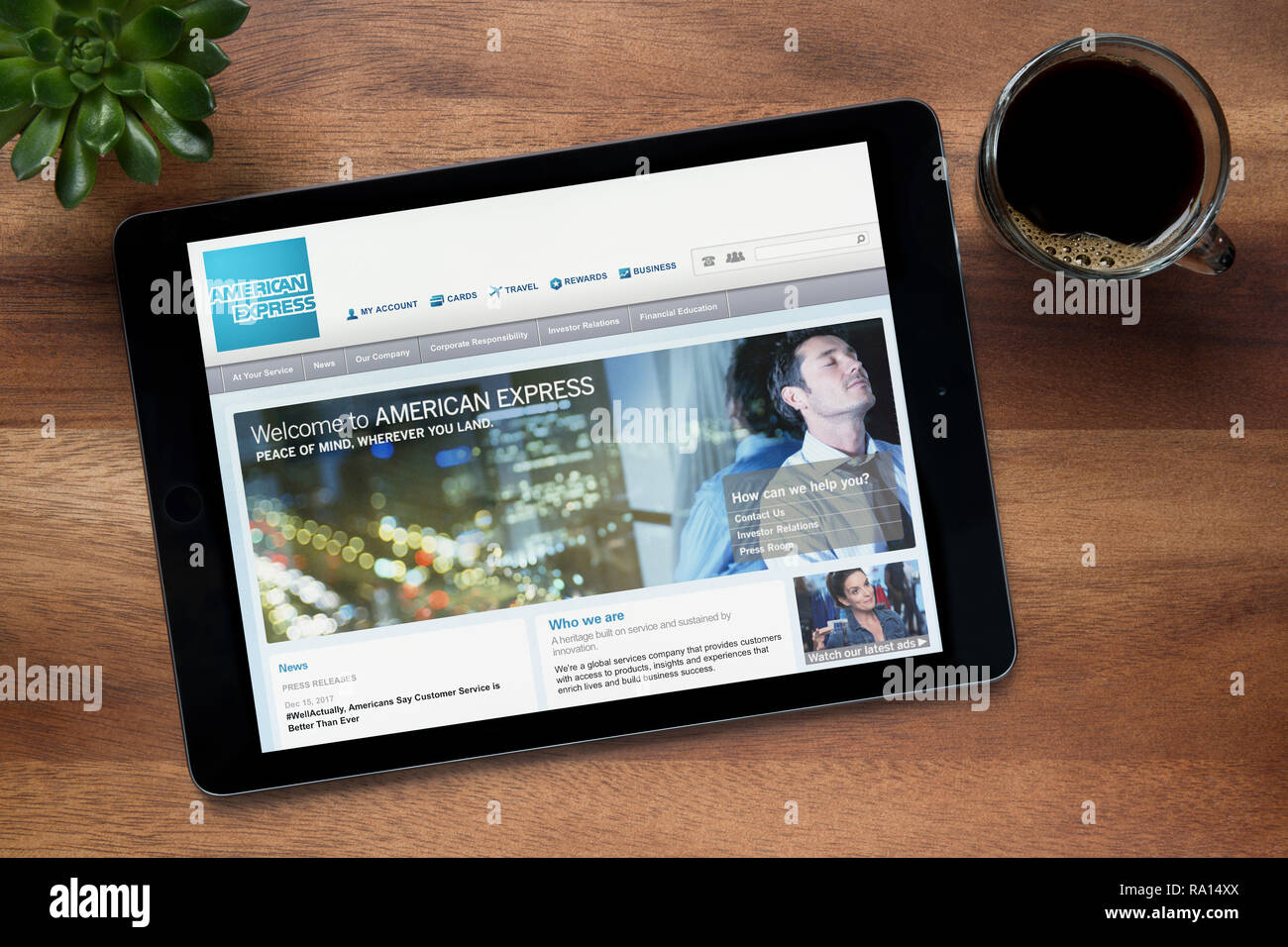 Die Website von American Express wird auf einem iPad Tablet gesehen, auf einer hölzernen Tisch zusammen mit einem Espresso und einem Haus Anlage (nur redaktionelle Nutzung). Stockfoto