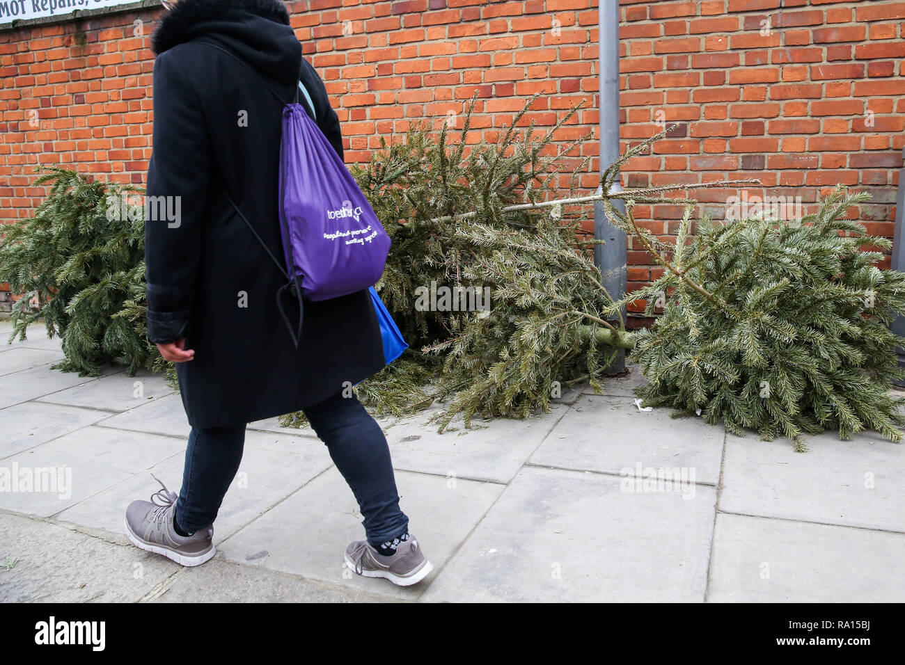 London, Großbritannien. 29 Dez, 2018. Eine Person gesehen letzten Weihnachtsbäume, die auf dem Gehsteig in Nord London nur vier Tage nach Weihnachten, gedumpt sind. Credit: Dinendra Haria/SOPA Images/ZUMA Draht/Alamy leben Nachrichten Stockfoto