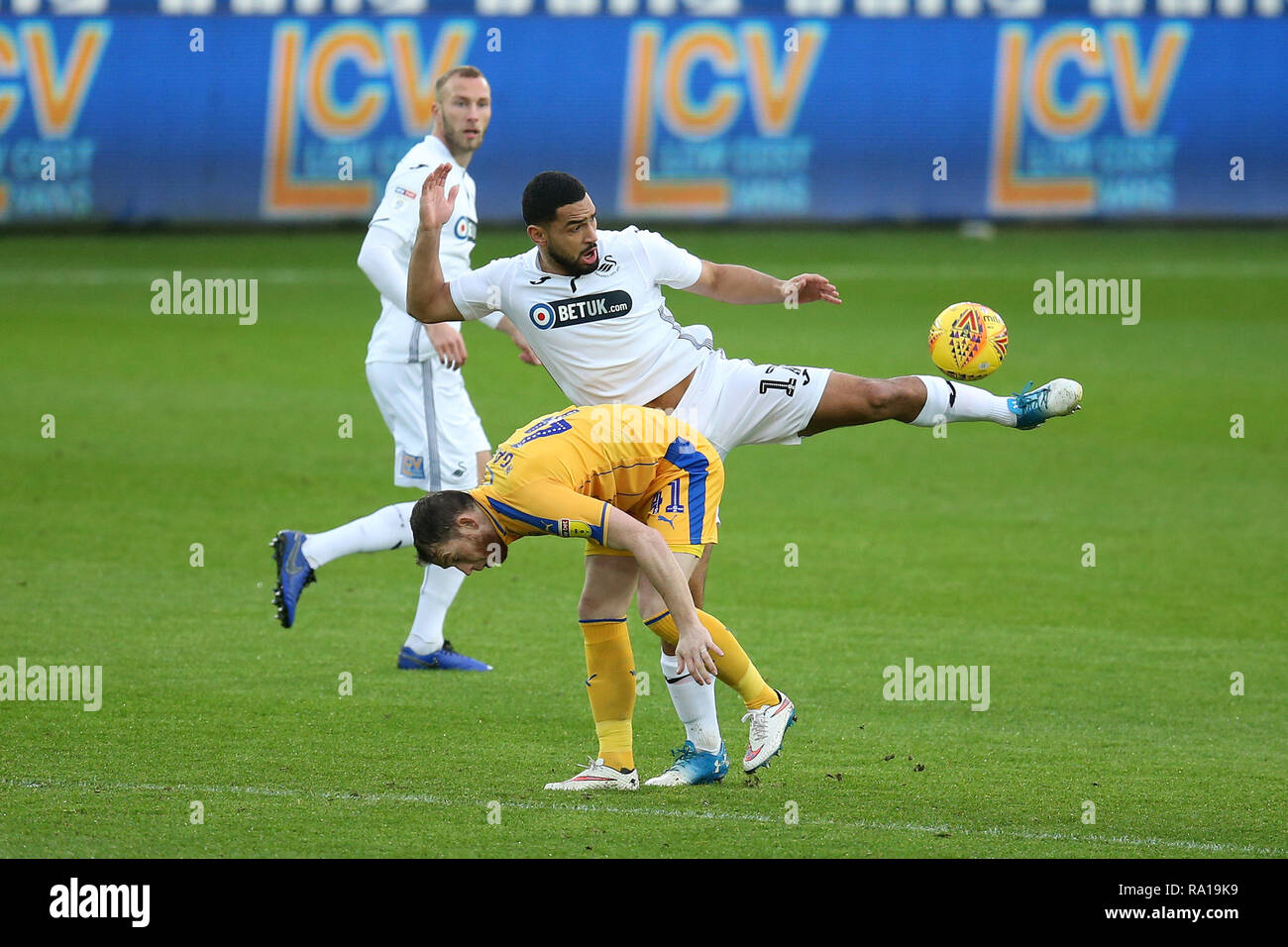 Swanswa, Wales, UK. 29. Dezember 2018. Cameron Carter-Vickers von Swansea City erhält der Ball vor Joe Garner von Wigan Athletic (l). EFL Skybet Meisterschaft übereinstimmen, Swansea City v Wigan Athletic in der Liberty Stadium in Swansea, Südwales am Samstag, den 29. Dezember 2018. Dieses Bild dürfen nur für redaktionelle Zwecke verwendet werden. Nur die redaktionelle Nutzung, eine Lizenz für die gewerbliche Nutzung erforderlich. Keine Verwendung in Wetten, Spiele oder einer einzelnen Verein/Liga/player Publikationen. pic von Andrew Obstgarten/Andrew Orchard sport Fotografie/Alamy leben Nachrichten Stockfoto