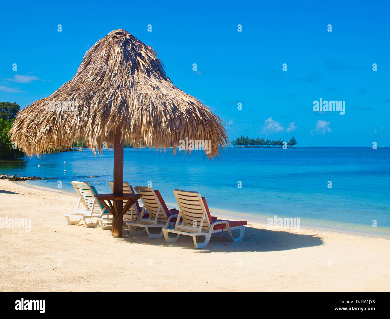 Palapa und Liegen am Strand. Roatan Insel Stockfoto