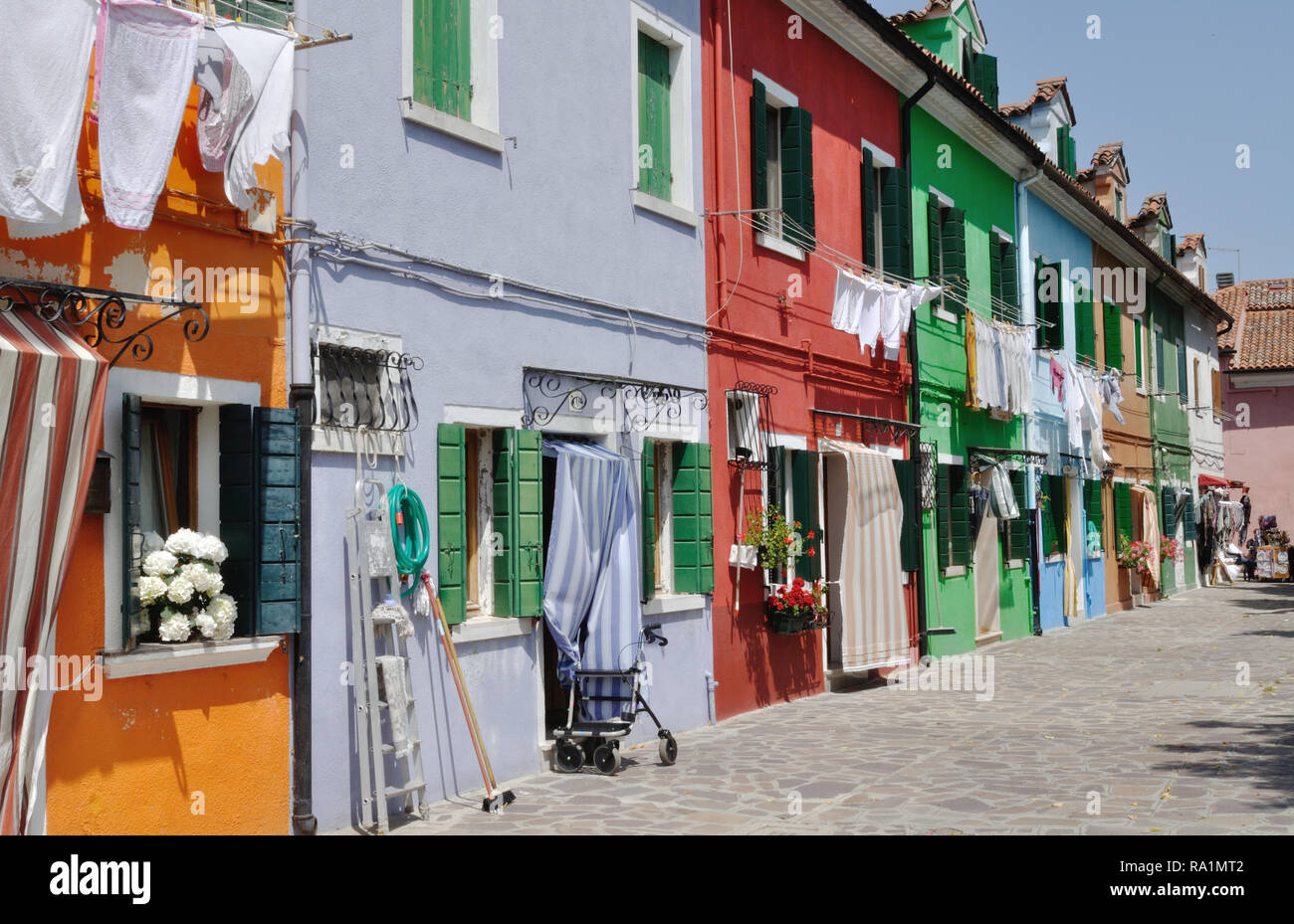 Bunte Häuser in einem Wohngebiet von Burano in der Lagune von Venedig, Italien. Beachten Sie die Wäsche trocknen auf der Wäscheleine im Freien. Stockfoto