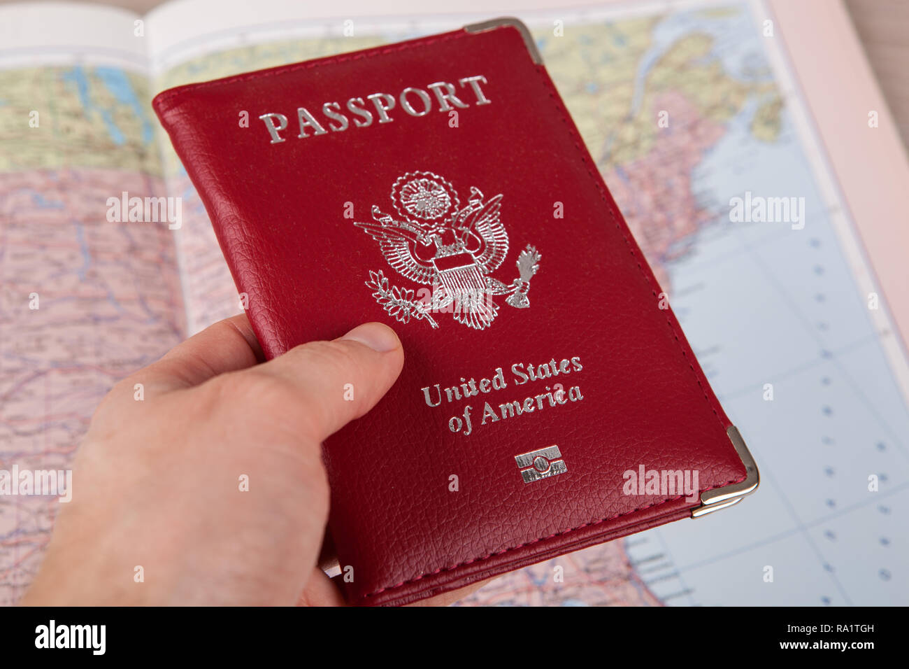 Amerikanischen Pass in der Hand gegen eine geographische Karte schließen Stockfoto