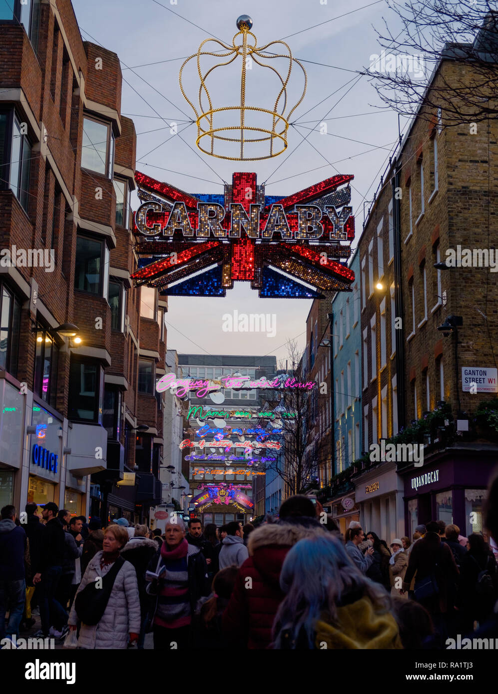 Käufer auf Carnaby Street, Soho, London unter Weihnachten Neon Licht Installation. Dezember 2018 Stockfoto