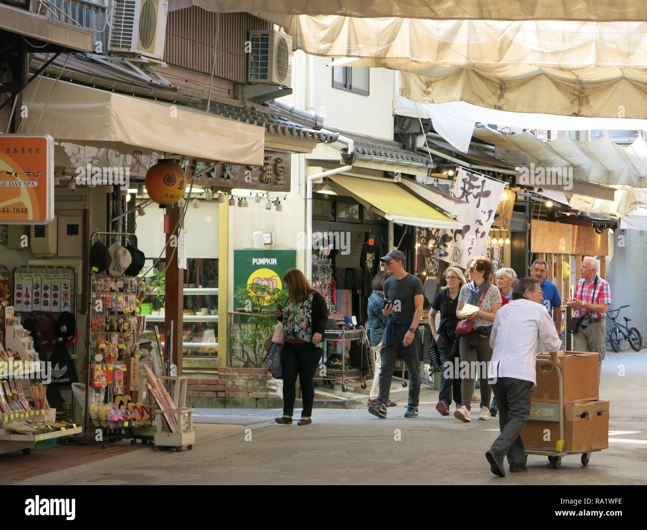 Street Scene, Miyajima Insel: Eine überdachte Straße ist voll von Geschäften für die Touristen; Japanische Skript auf die Banner und Laternen. Stockfoto