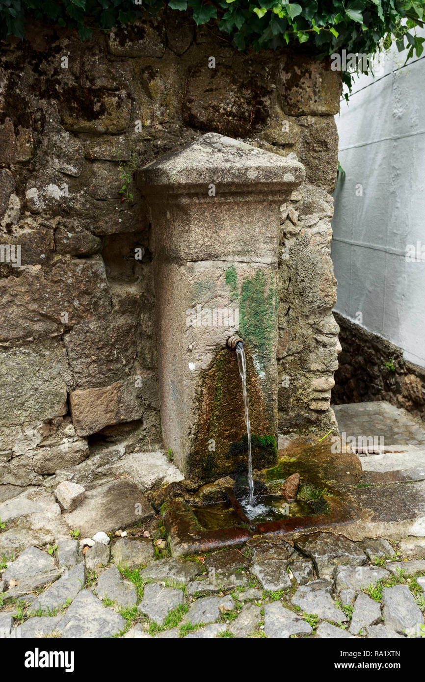 Kleiner Brunnen mit kontinuierlicher fließendes Wasser in einer engen Straße von Linhares Da Beira, Beira Alta, Portugal gefunden Stockfoto