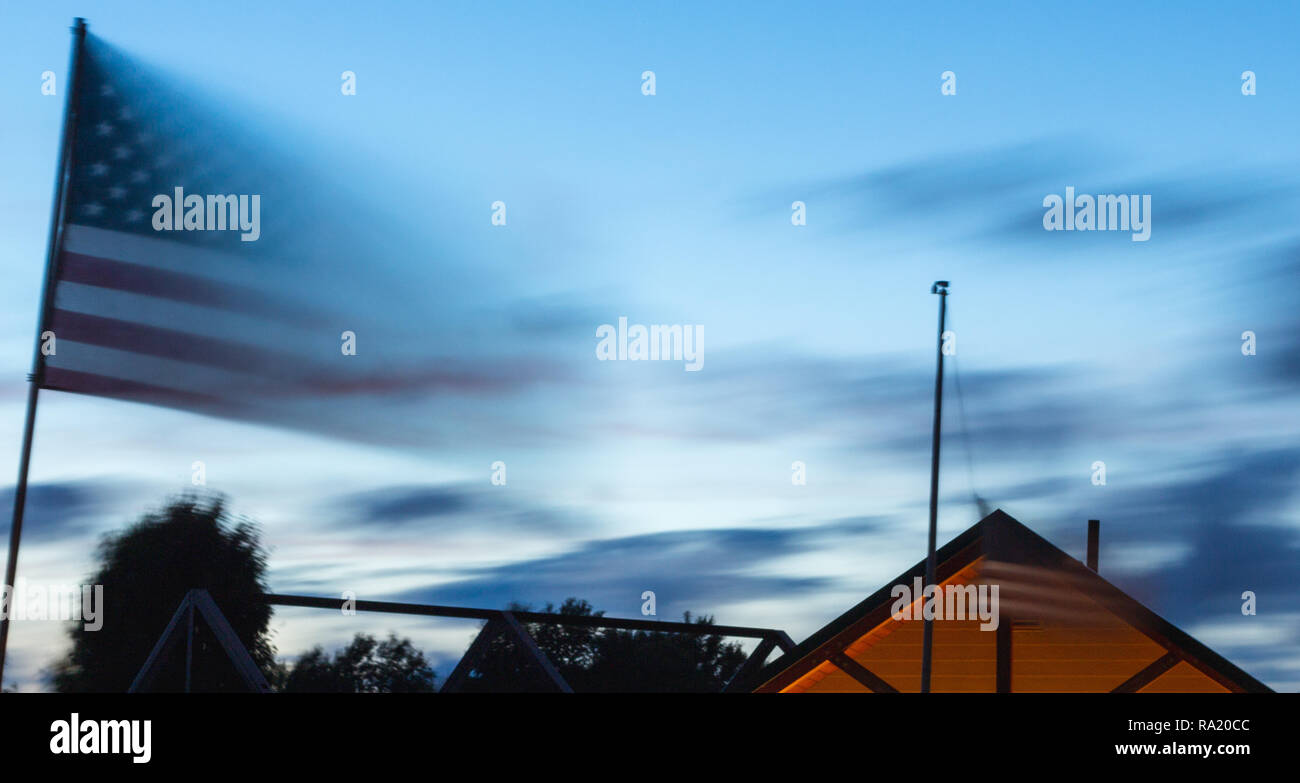 Zwei flags beginnen mit der untergehenden Sonne zu verblassen. Stockfoto