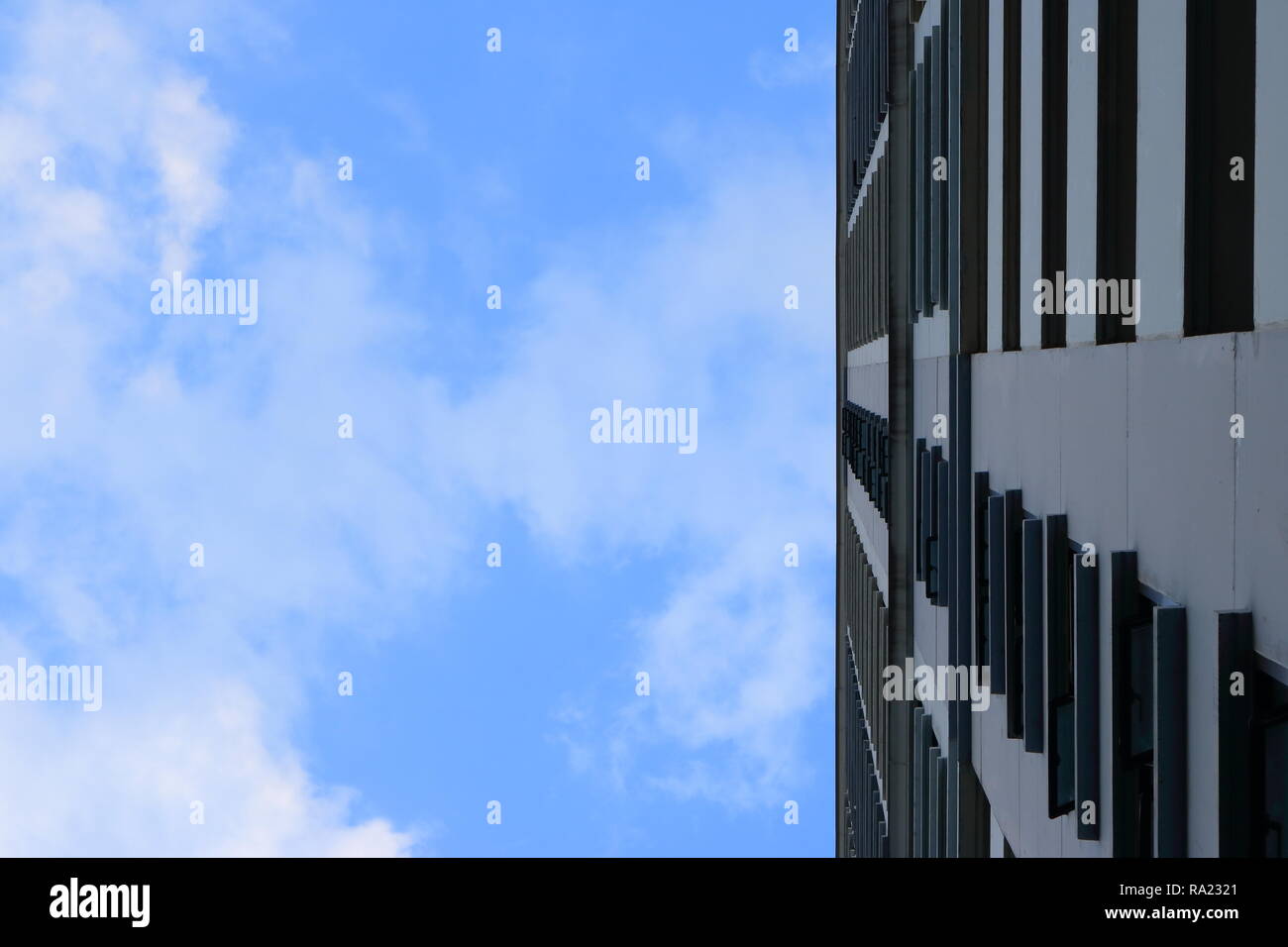Blauer Himmel mit weißen Wolken über hohe Gebäude Stockfoto