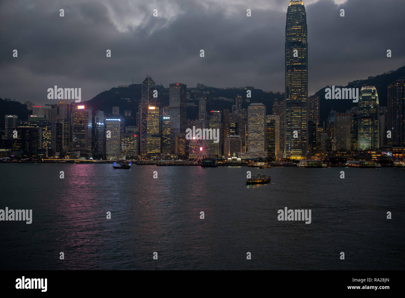 Schwere wolken Webstuhl über dem glitzernden Türmen von Hong Kong Central District als Nacht rollt. Stockfoto