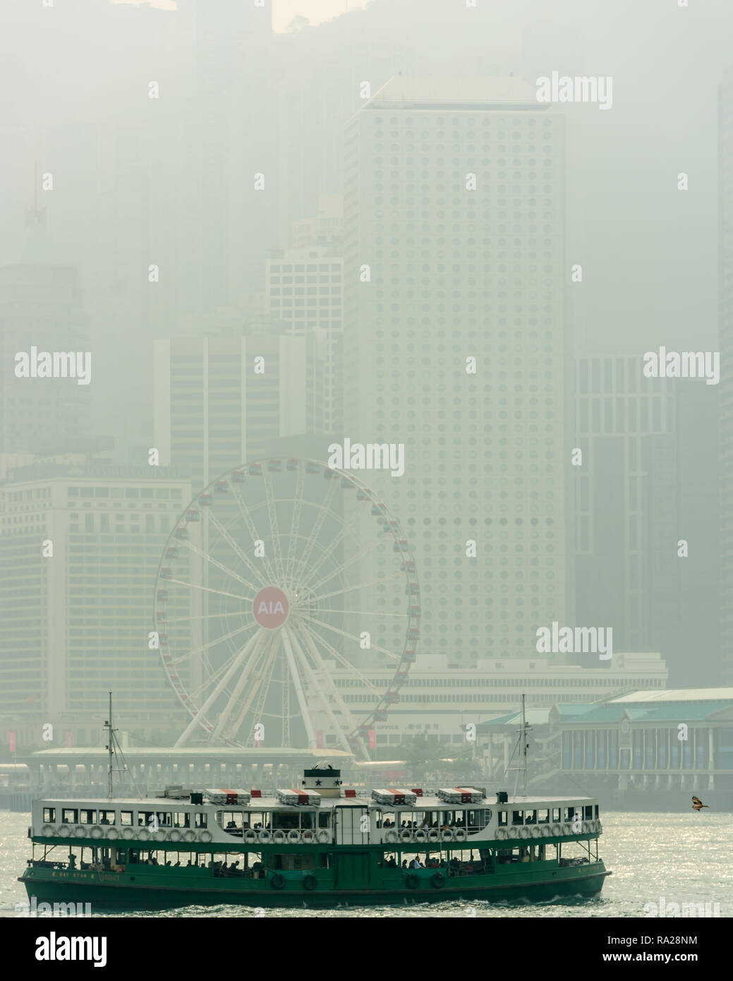 Eine braune Drachen folgt der 'Day Star' Star Ferry auf seiner Route von der zentralen auf die Tsim Sha Tsui, vor dem Hintergrund der HK Riesenrad Stockfoto