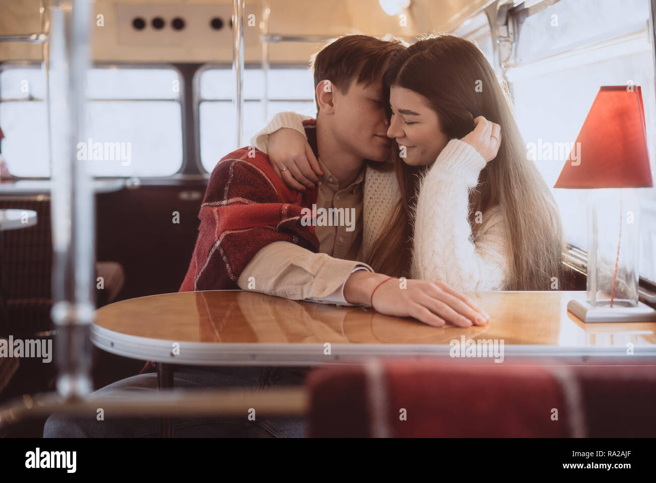 Liebevolle junge Paar im Winter in einem Cafe sitzen Stockfoto