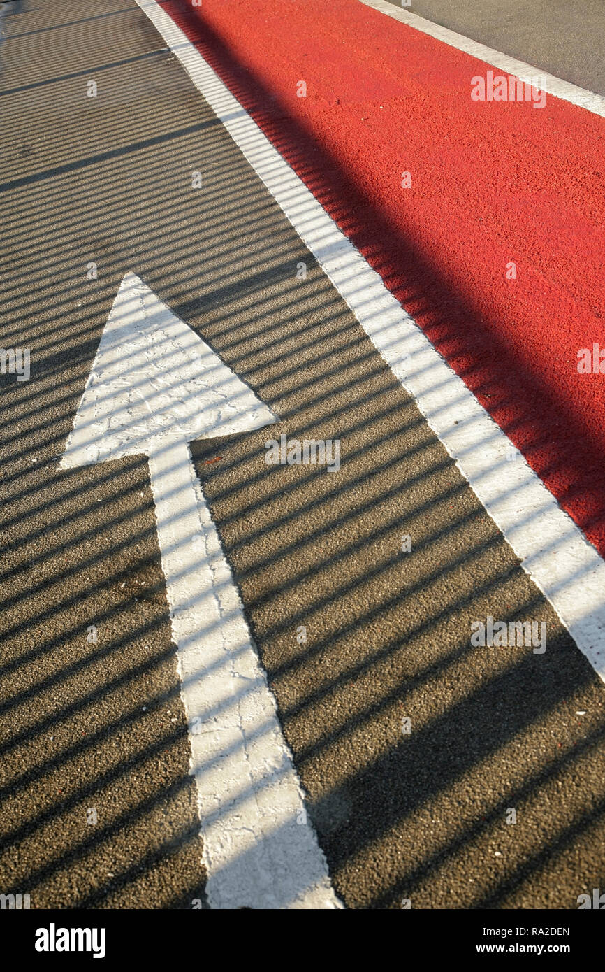 Weißer Pfeil auf der Fahrbahn. Stockfoto