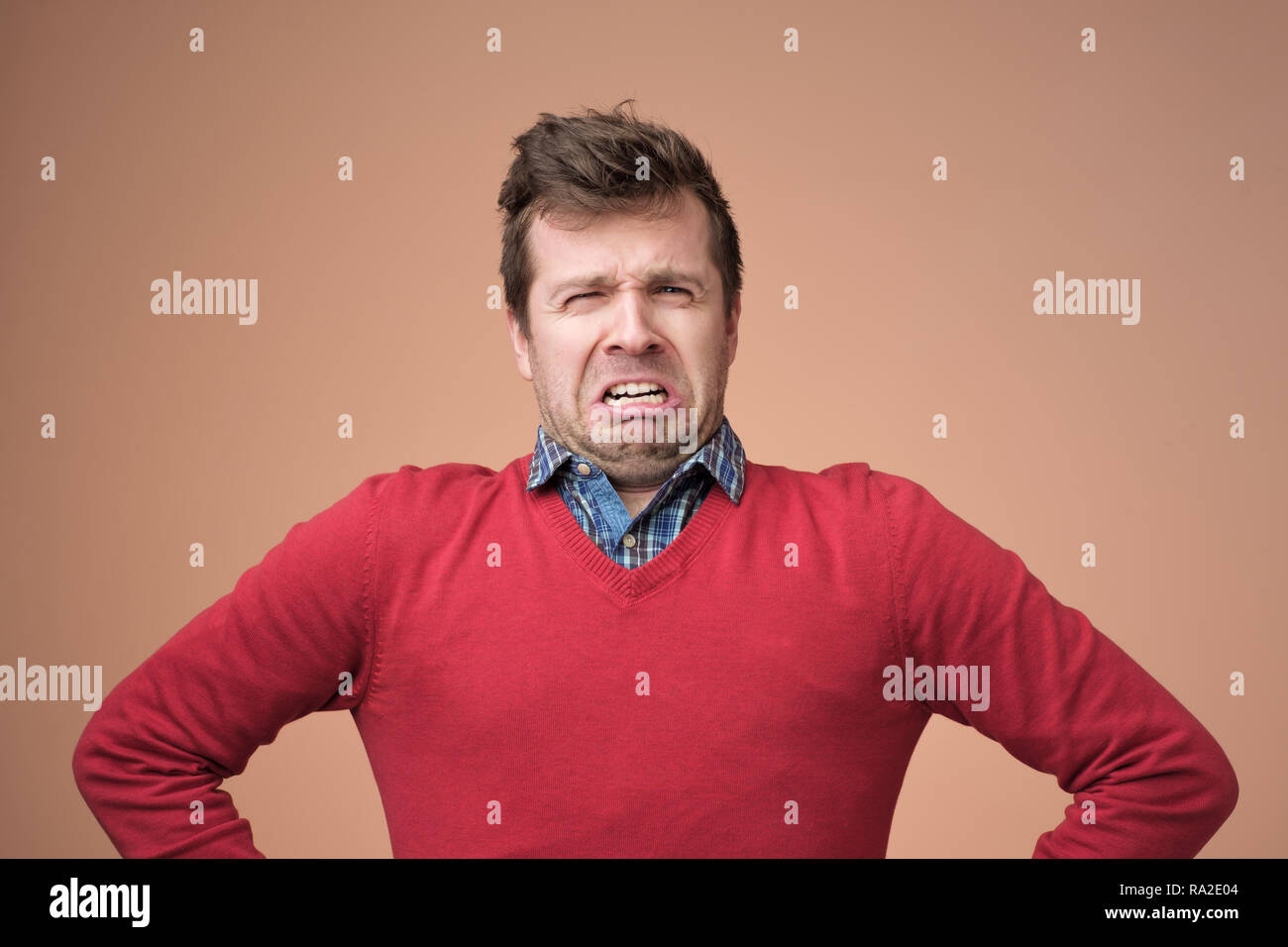 Mann Schmollen und runzelte die Augenbrauen, mit grausamen Worten beleidigt wird, Stockfoto