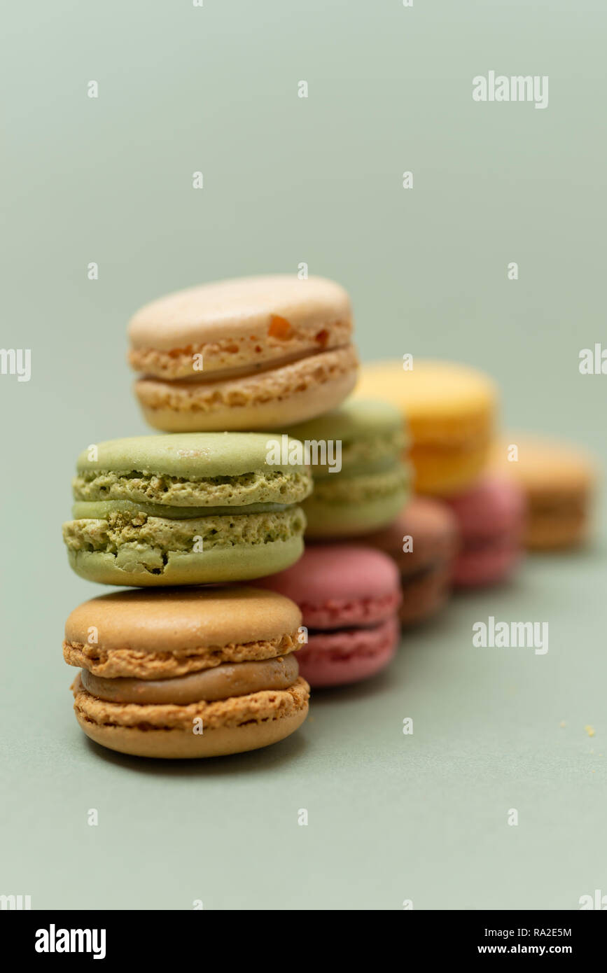 Vintage pastellfarbenen Französische Makronen oder Macarons auf grünem Hintergrund Stockfoto