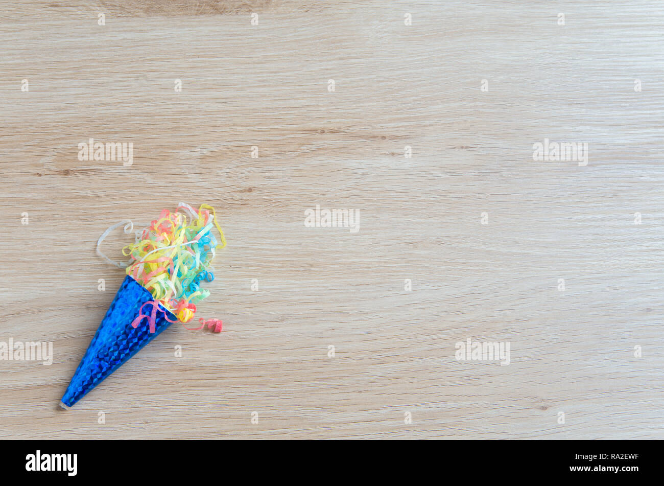 Blau knallte Party popper auf einem Holztisch Stockfoto