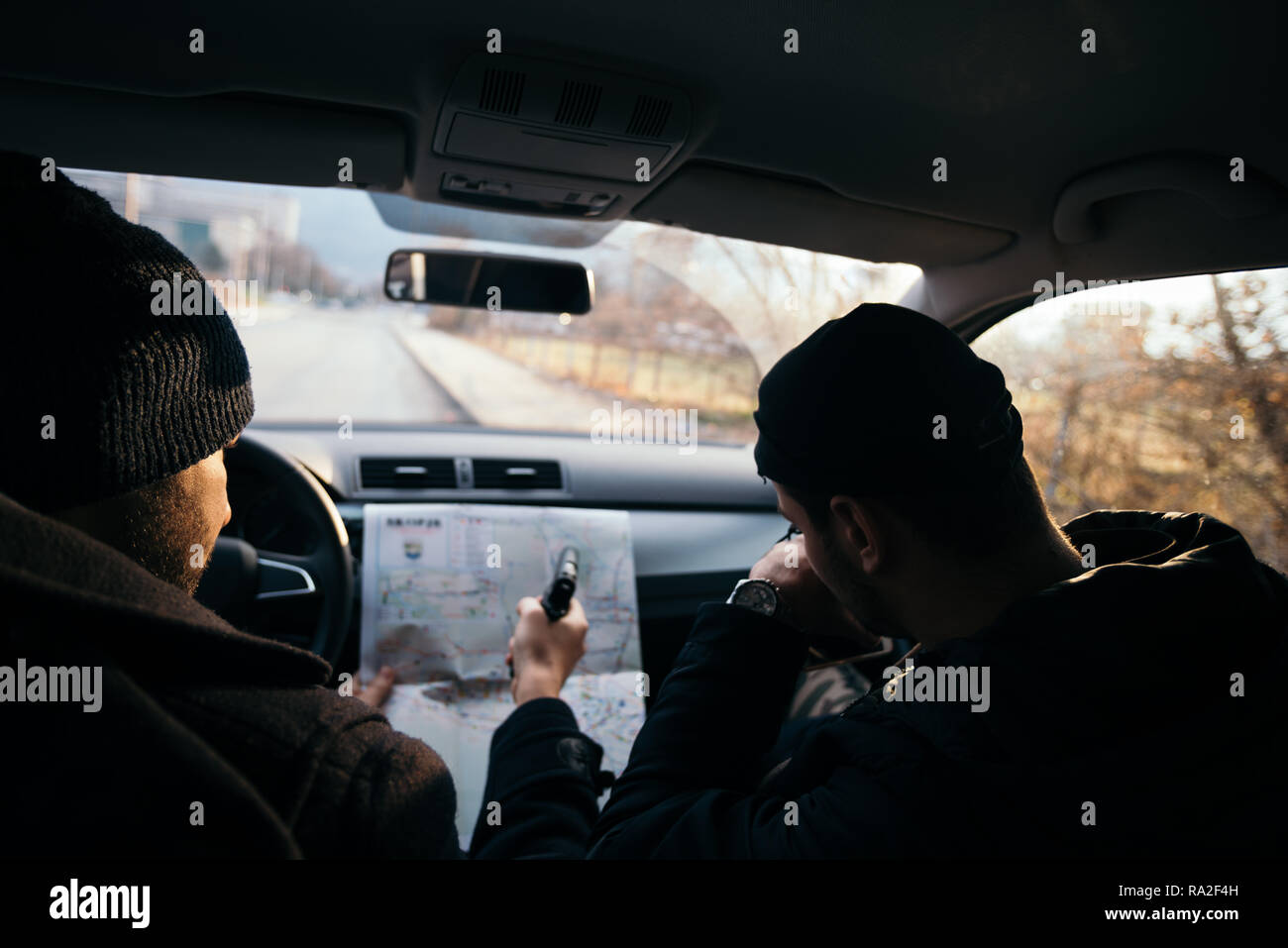 Kriminelle bei Sonnenuntergang in einem Auto sitzen, auf dem Stadtplan  suchen und Ihre nächsten Schritte zu planen Stockfotografie - Alamy
