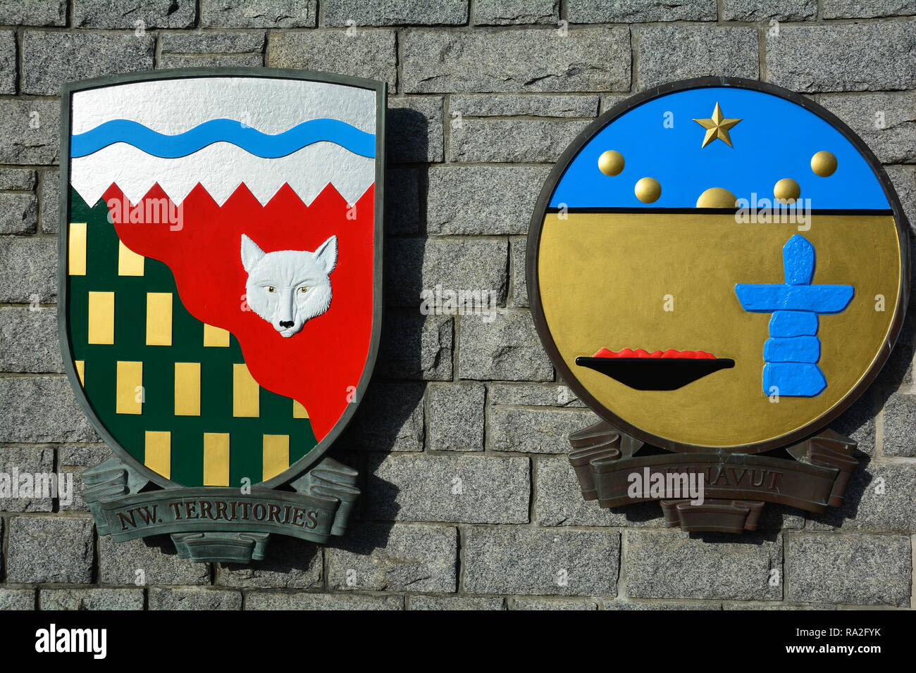 Wappen für die Northwest Territories und Nunavut hängen an einer Felswand in Victoria BC, Kanada. Stockfoto