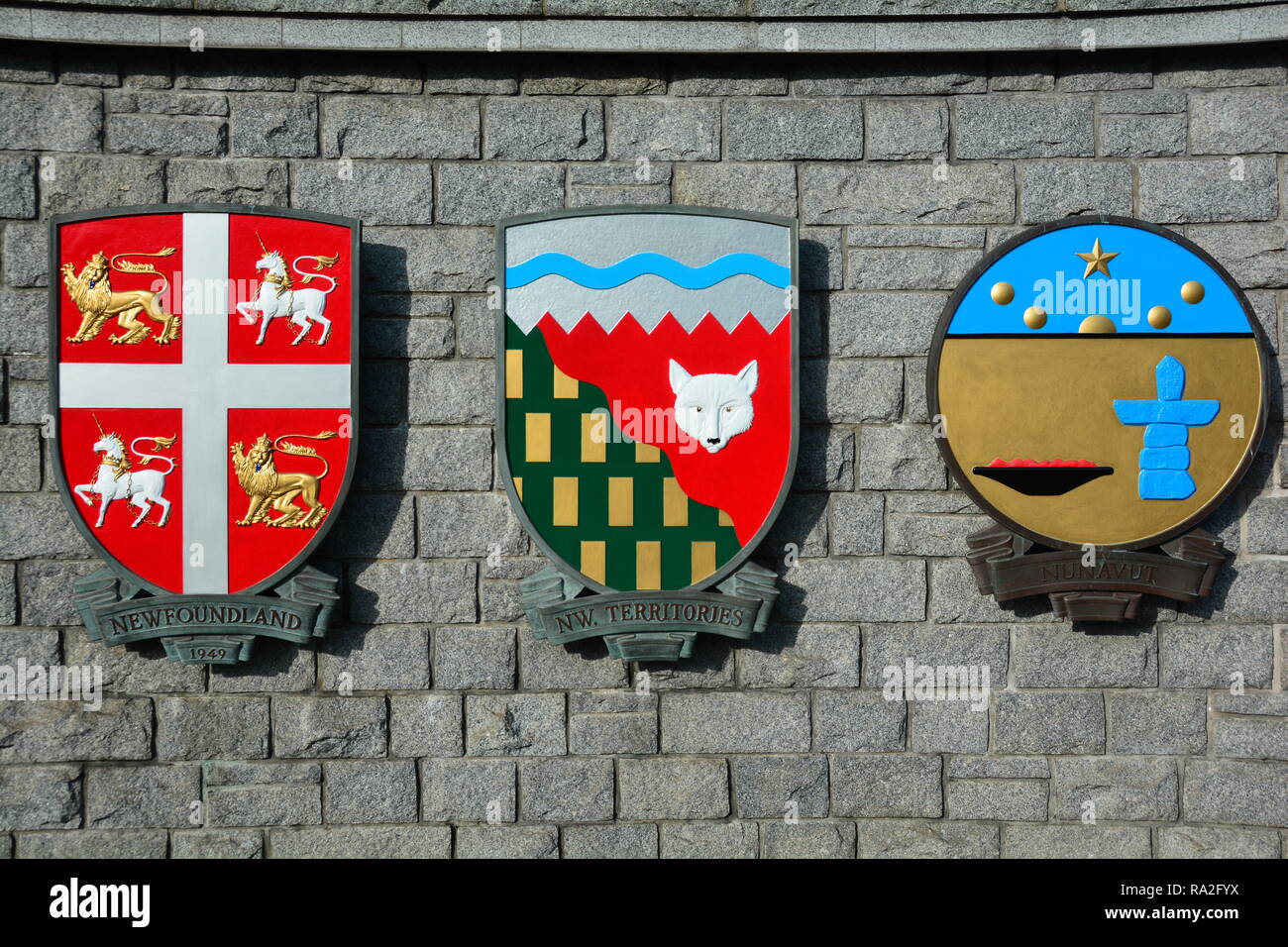 Wappen für die kanadische Provinz Neufundland, die Northwest Territories und Nunavut hängen an einer Wand in Victoria BC, Kanada. Stockfoto