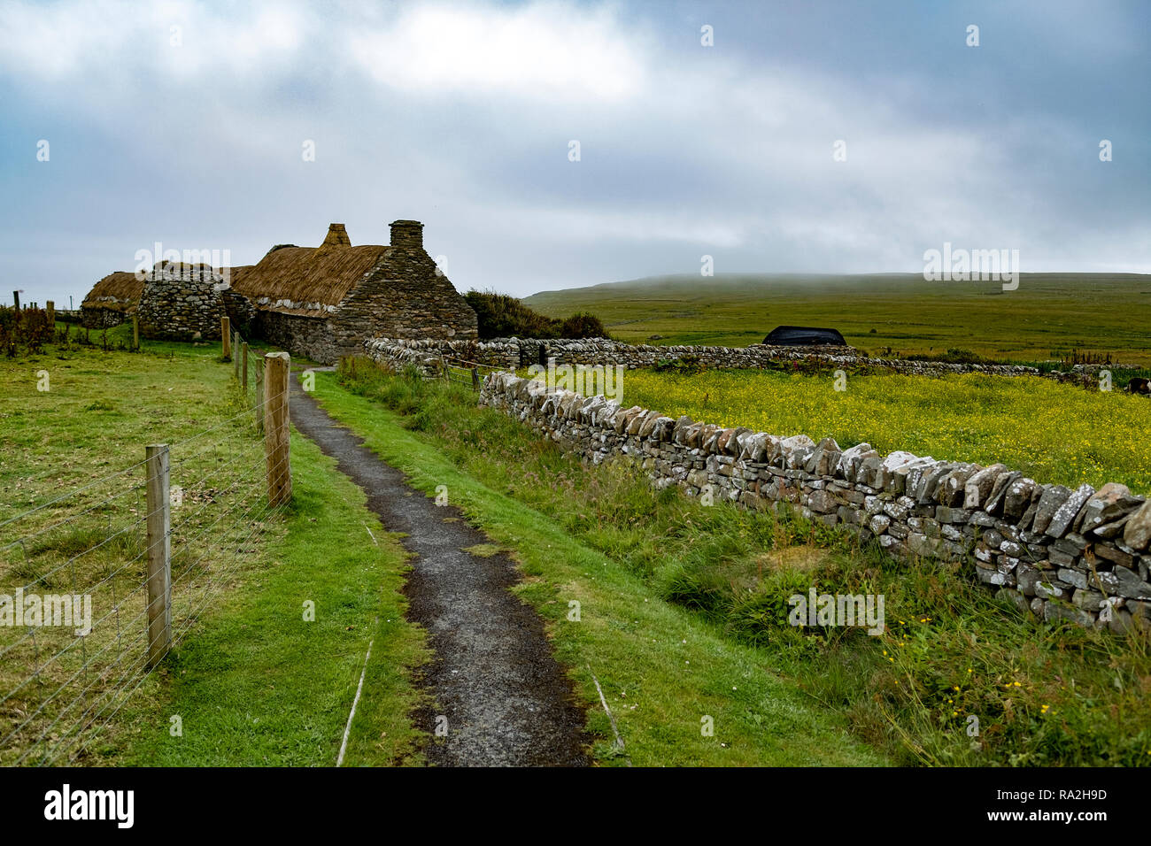 Croft House und Weide mit Steinmauern auf dem Festland Insel der schottischen Shetland-Inseln an einem bewölkten Tag Stockfoto