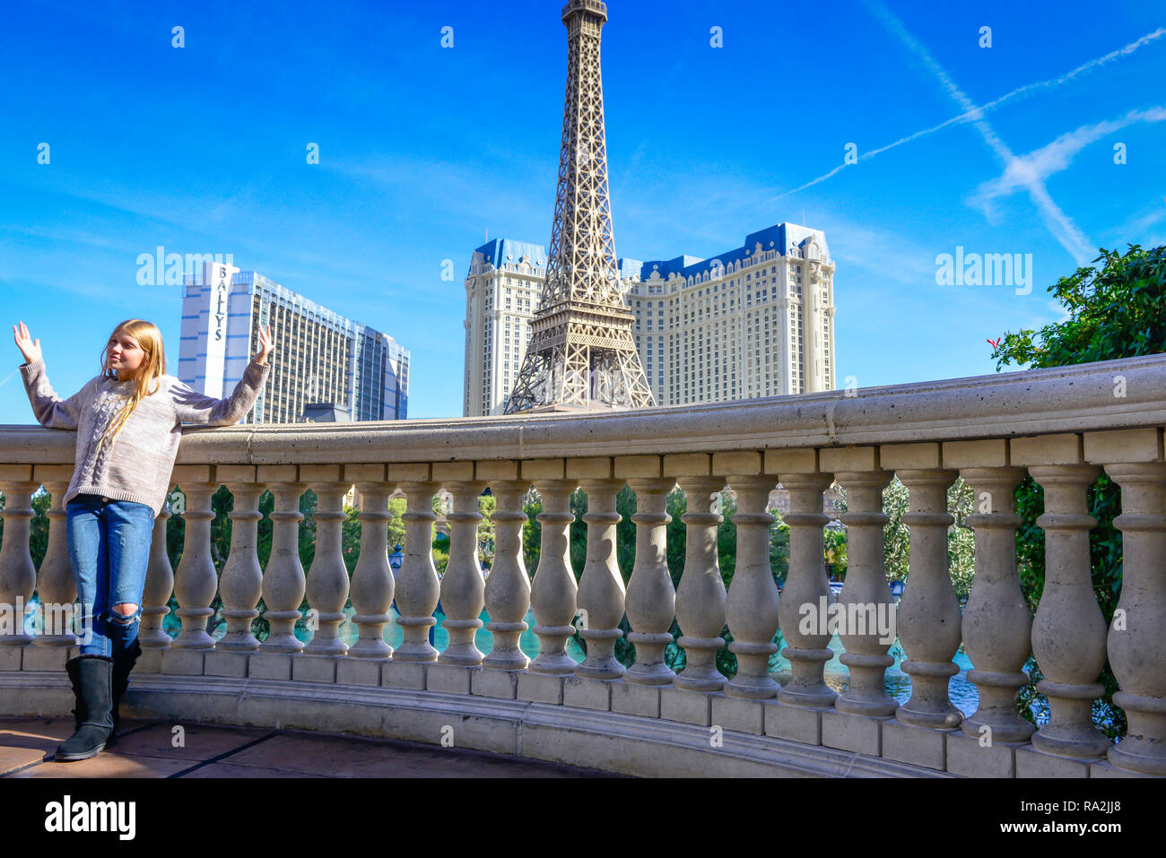 Tween Girl posiert für Fotografie vor dem Paris Hotel und Casino's Replik des Effile Turm aus dem balastrade des Bellagio anzeigen Stockfoto