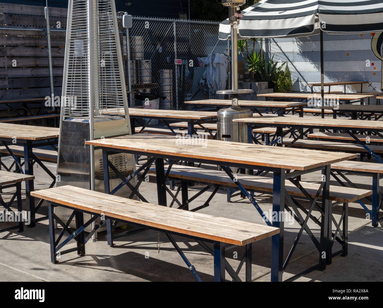 Outdoor Picknick Tischen und Sonnenschirmen in einem Außenbereich Restaurant Brauerei Essbereich während der sonnigen Tag Stockfoto