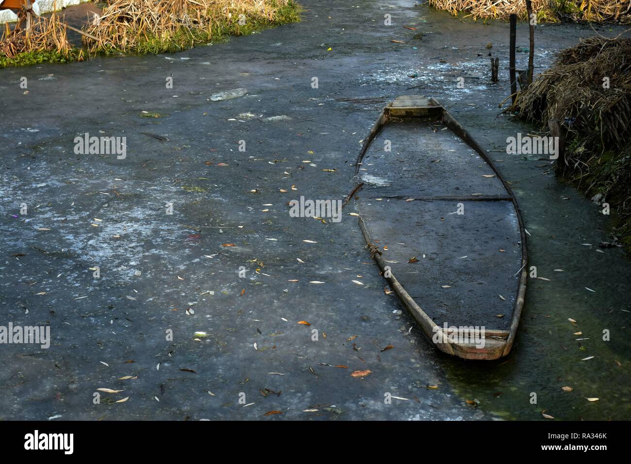 Dezember 31, 2018 - Srinagar, J&K, Indien - ein Boot gesehen in den gefrorenen Dal Lake an einem kalten Tag in Srinagar, Indien verwalteten Kaschmir stecken. Kalte Welle wieder schwer das Kaschmir-tal gegriffen am Montag, das Wetteramt sagte. Nach einem offiziellen das Department MET die minimale Temperatur betrug minus 6,6 Grad Celsius in Srinagar. Der Kaschmir Valley ist durch den 40 Tage langen harten Winter kalt wie die''˜ Chillai Kalanâ Credit: Saqib Majeed/SOPA Images/ZUMA Draht/Alamy Leben Nachrichten bekannt Stockfoto