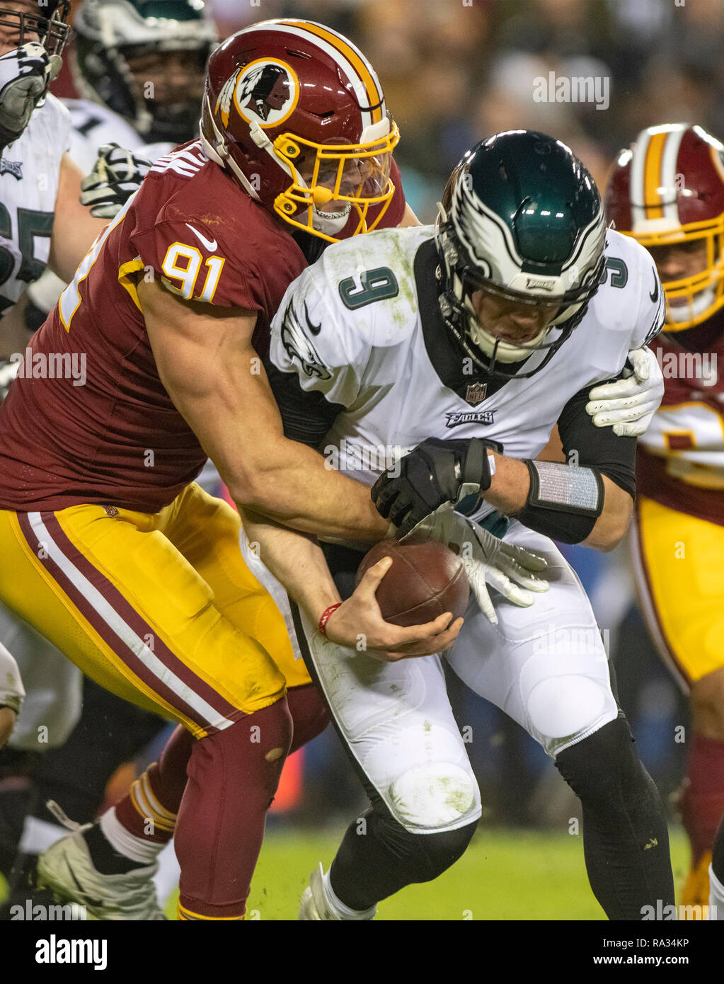 Washington Redskins außerhalb Linebacker Ryan Kerrigan (91) Säcke Philadelphia Eagles quarterback Nick Foles (9) Im vierten Quartal ihr Spiel an FedEx Field in Landover, Maryland am 30. Dezember 2018. Die Adler gewannen das Spiel 24-0 und ihren Sieg verbunden mit der Viking Verlust erlaubt Ihnen die NFC Endspiele zu gelangen. Credit: Ron Sachs/CNP/MediaPunch Stockfoto