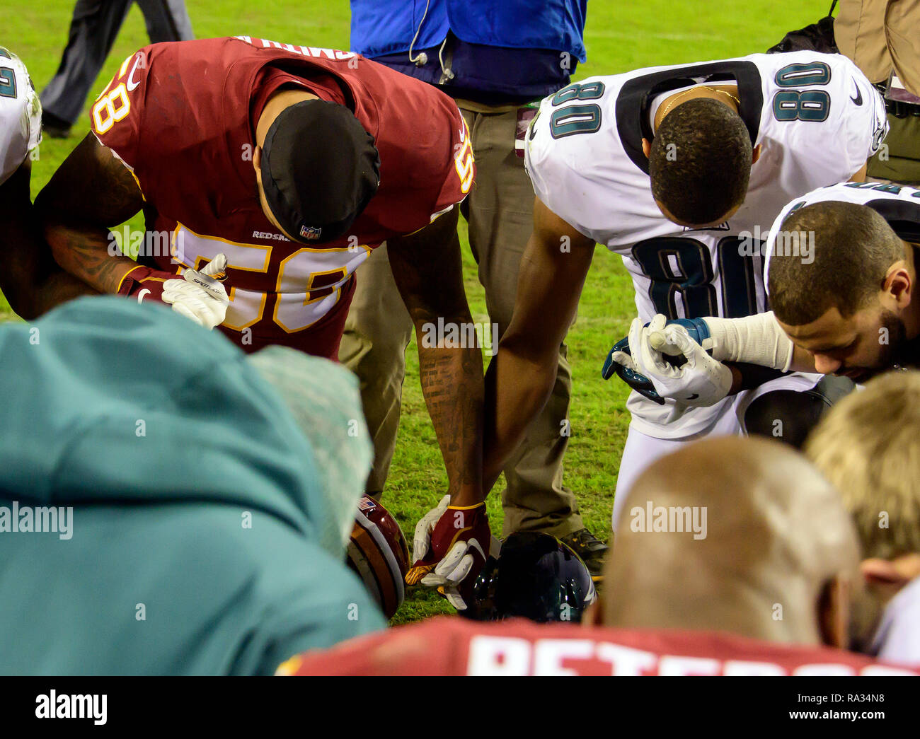 Washington Redskins linebacker Zach Vigil (58) und Philadelphia Eagles wide receiver Jordanien Matthews (80) Halten Sie Hände, als sie nach ihrem Spiel bei FedEx Field in Landover, Maryland am 30 Dezember, 2018 beten. Die Adler gewannen das Spiel 24-0 und ihren Sieg verbunden mit der Viking Verlust erlaubt Ihnen die NFC Endspiele zu gelangen. Credit: Ron Sachs/CNP/MediaPunch Stockfoto