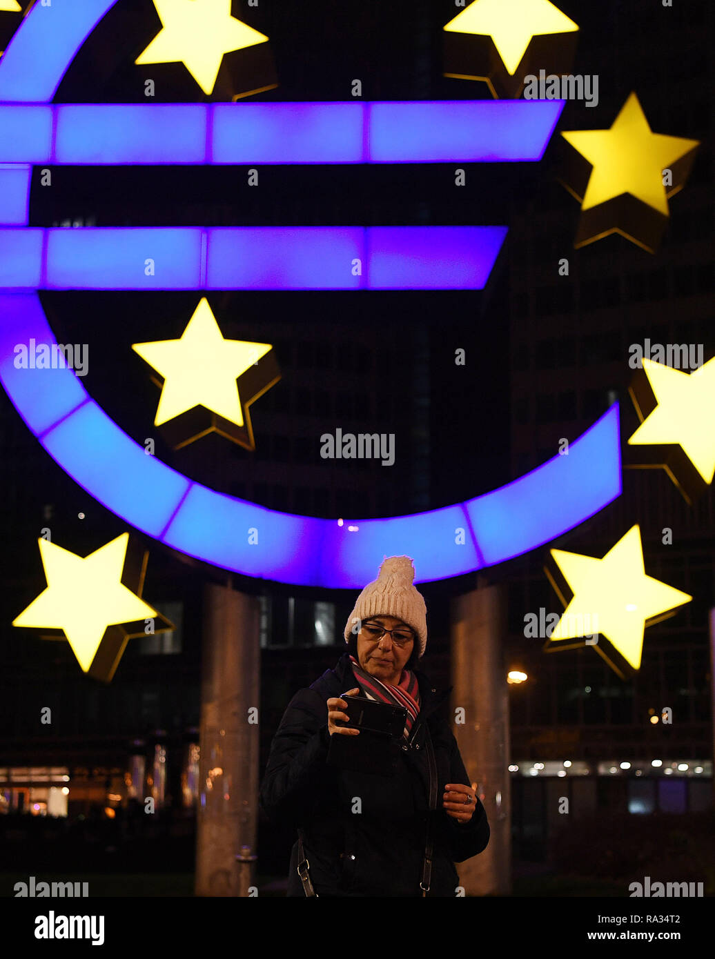 Peking, Europas gemeinsame Währung. 1 Jan, 2019. Eine Frau steht vor einer euro Skulptur in Frankfurt, Deutschland, Dez. 30, 2018. Der Euro - Europas gemeinsame Währung, wird 20 zum 1. Januar 2019. Credit: Lu Yang/Xinhua/Alamy leben Nachrichten Stockfoto